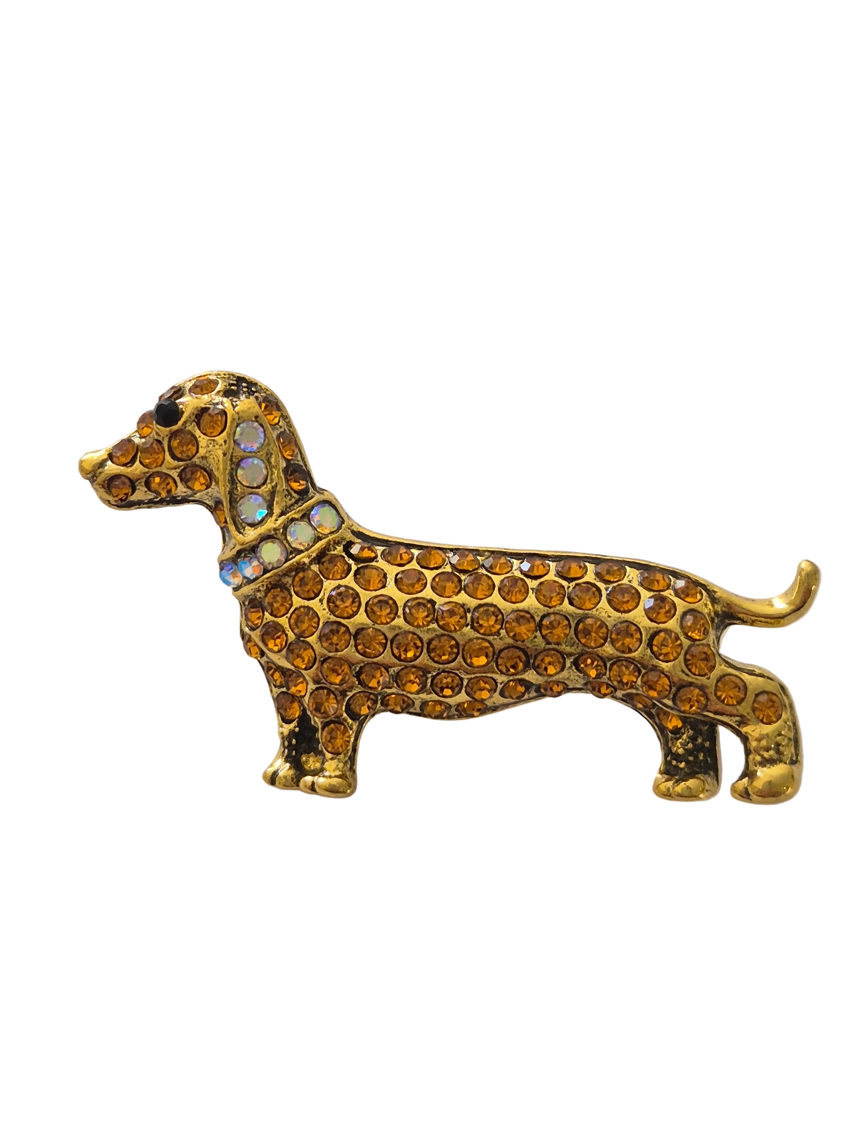 Gold dachshund dog brooch with gemstones on a white background