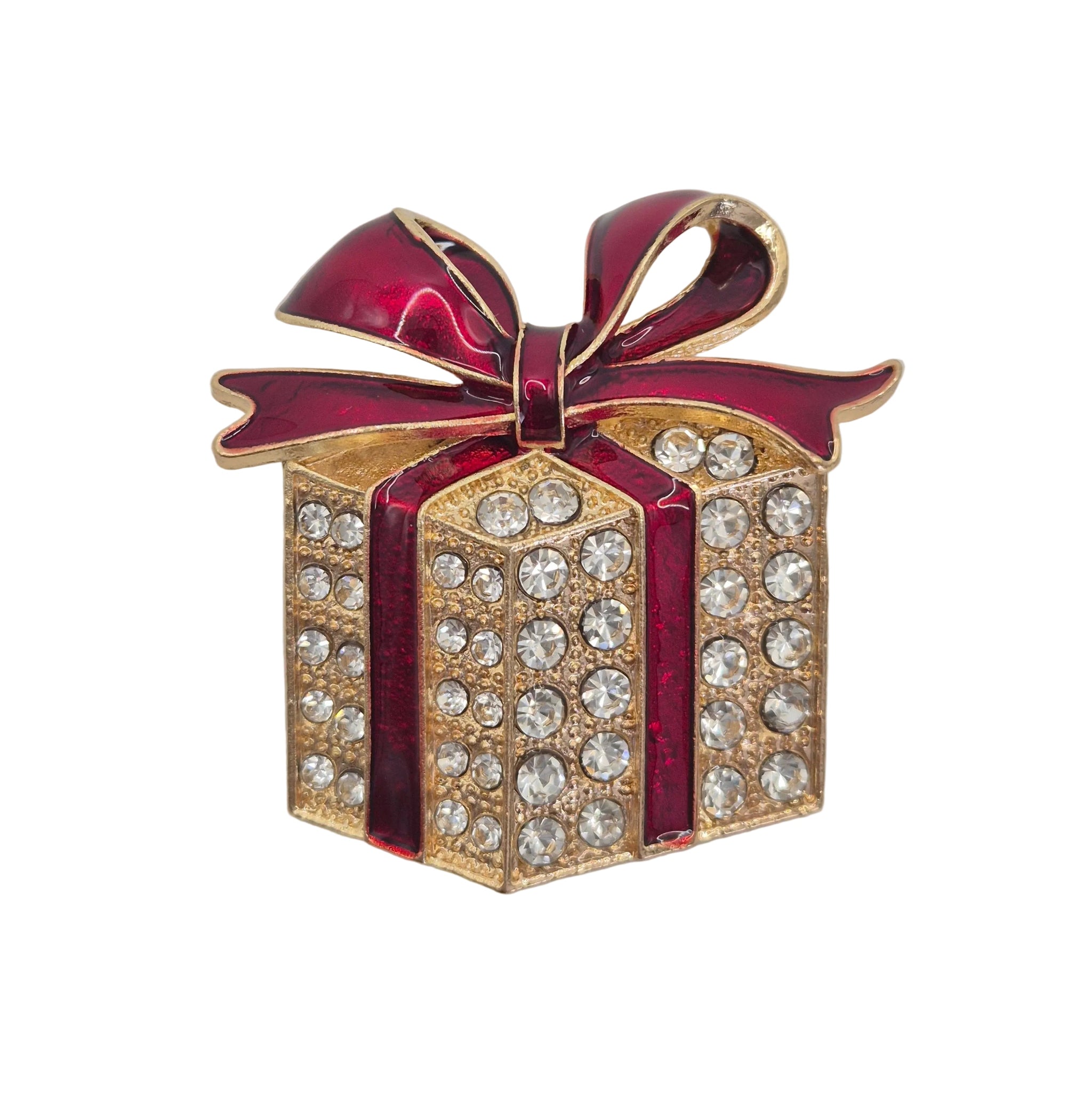A gold-tone gift box brooch embellished with clear rhinestones and accented with a glossy dark red enamel ribbon and bow, set against a plain light white background.