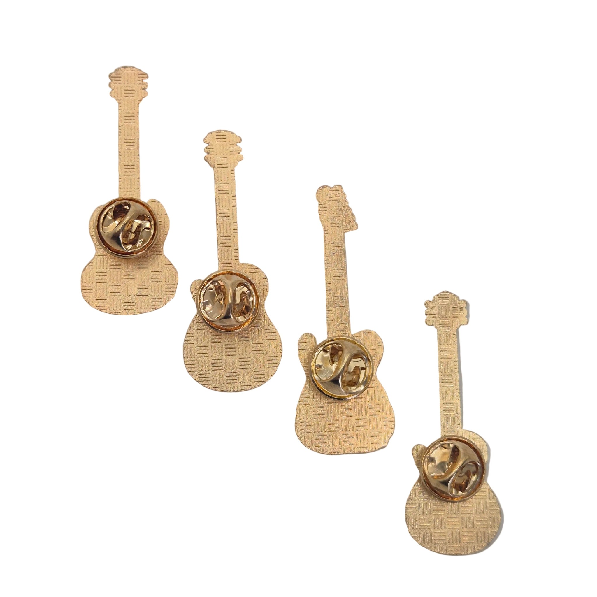 Four gold guitar-shaped lapel pins arranged diagonally on a light gray background.