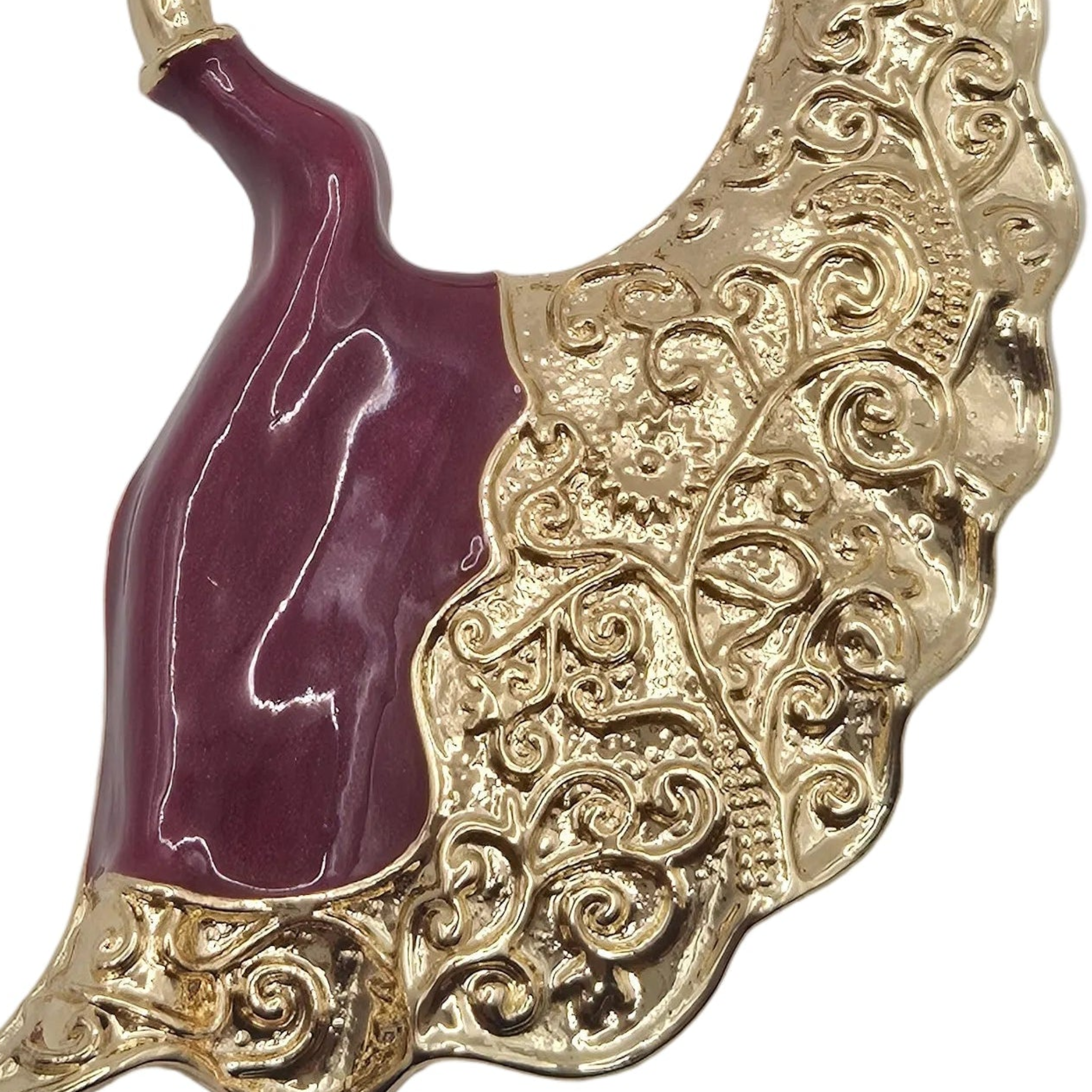 Gold-tone dancing woman brooch with burgundy enamel dress, ornate flowing skirt. Shown against a plain white background.