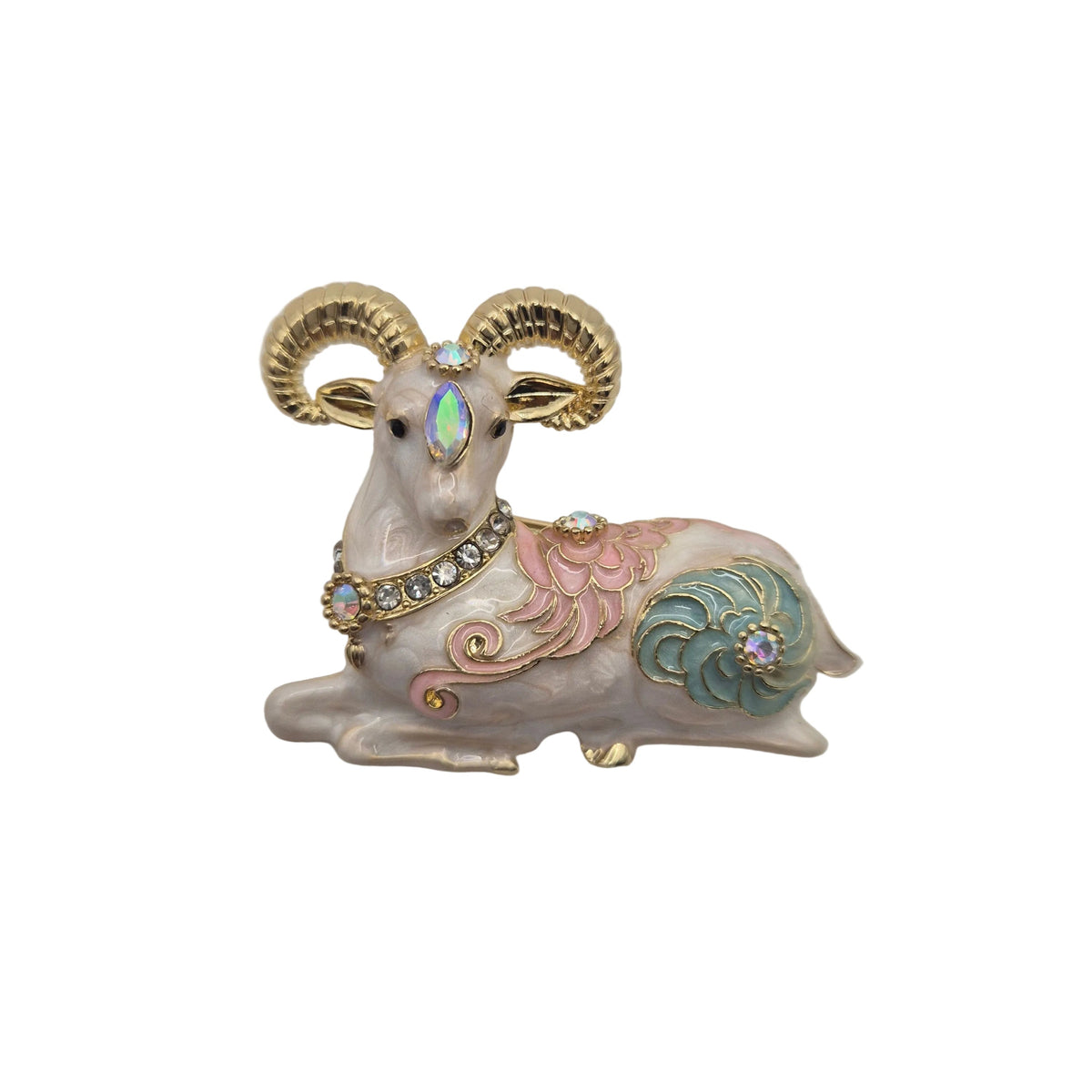 A decorative ram brooch with gold-toned horns, a pale pink body, pastel pink and teal accents, and small rhinestone details, photographed on a plain white background.