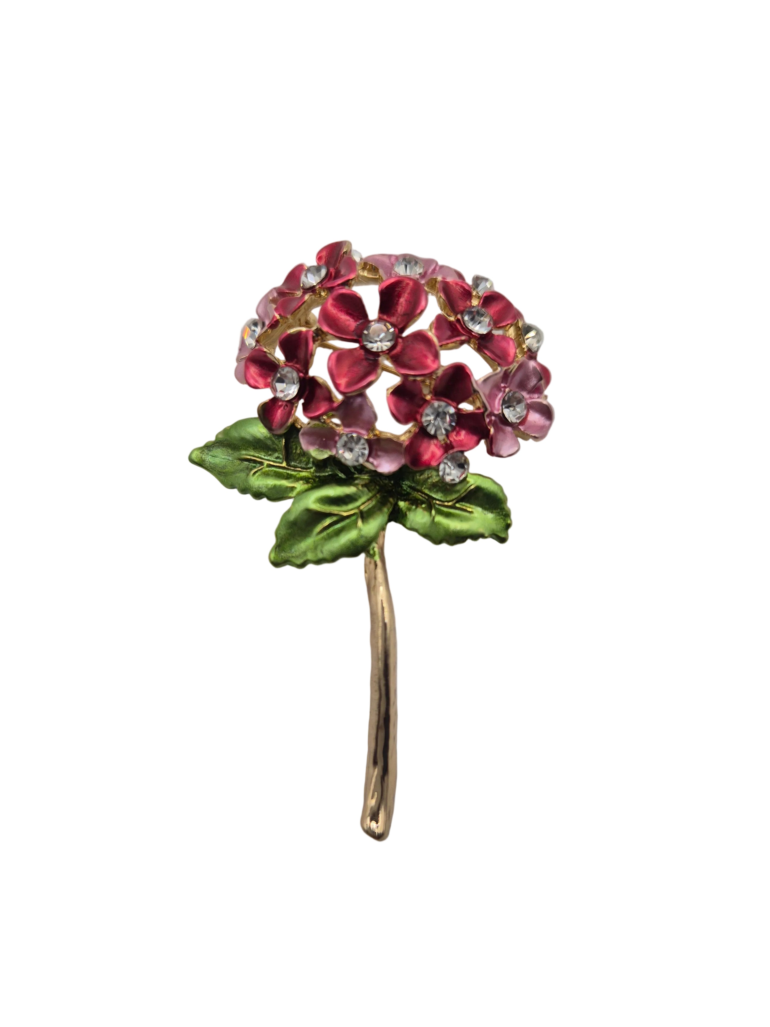 Floral brooch with pink flowers and green leaves on a white background
