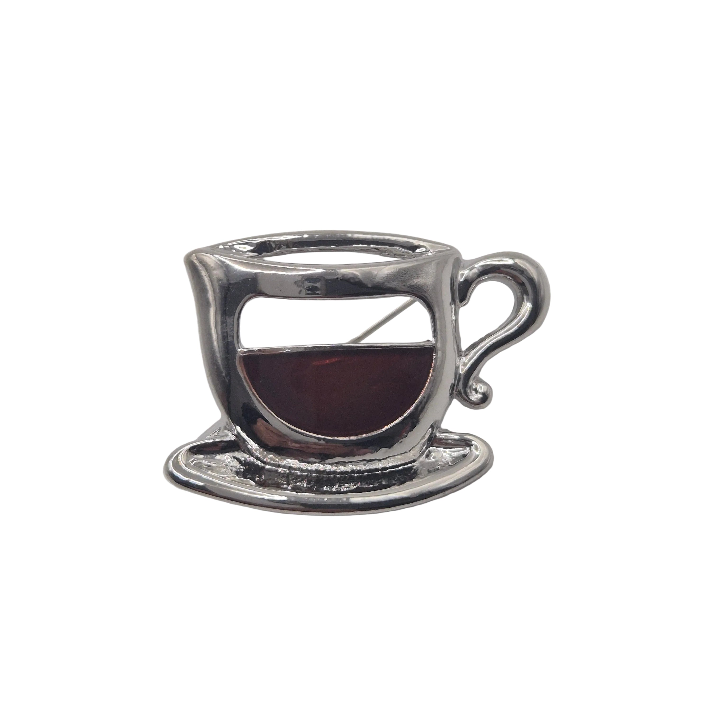 Silver metal coffee cup brooch on white background