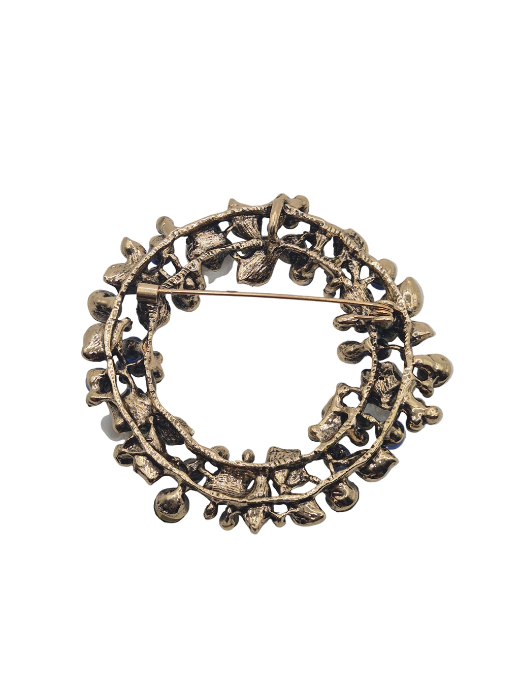 Blue floral brooch with leaf design on a white background