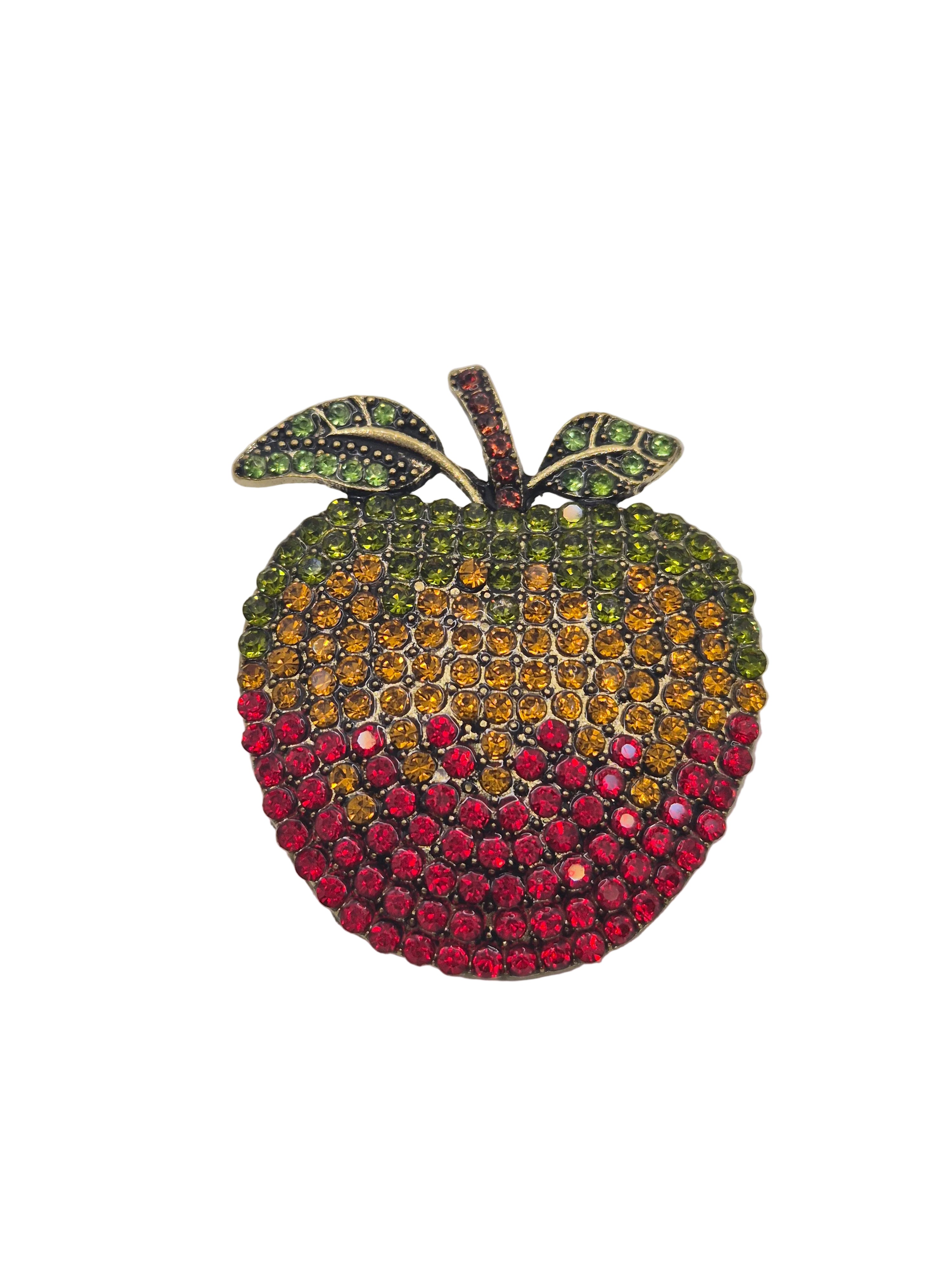 Colorful apple-shaped brooch with gemstones on a white background