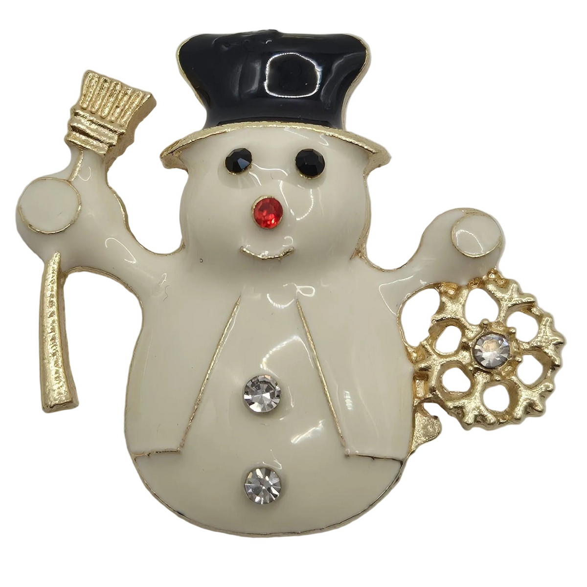 A snowman-shaped brooch with an off-white enamel body, a black top hat, gold trim, a gold paintbrush in one hand, and a gold snowflake in the other, accented with black, red, and clear rhinestones.