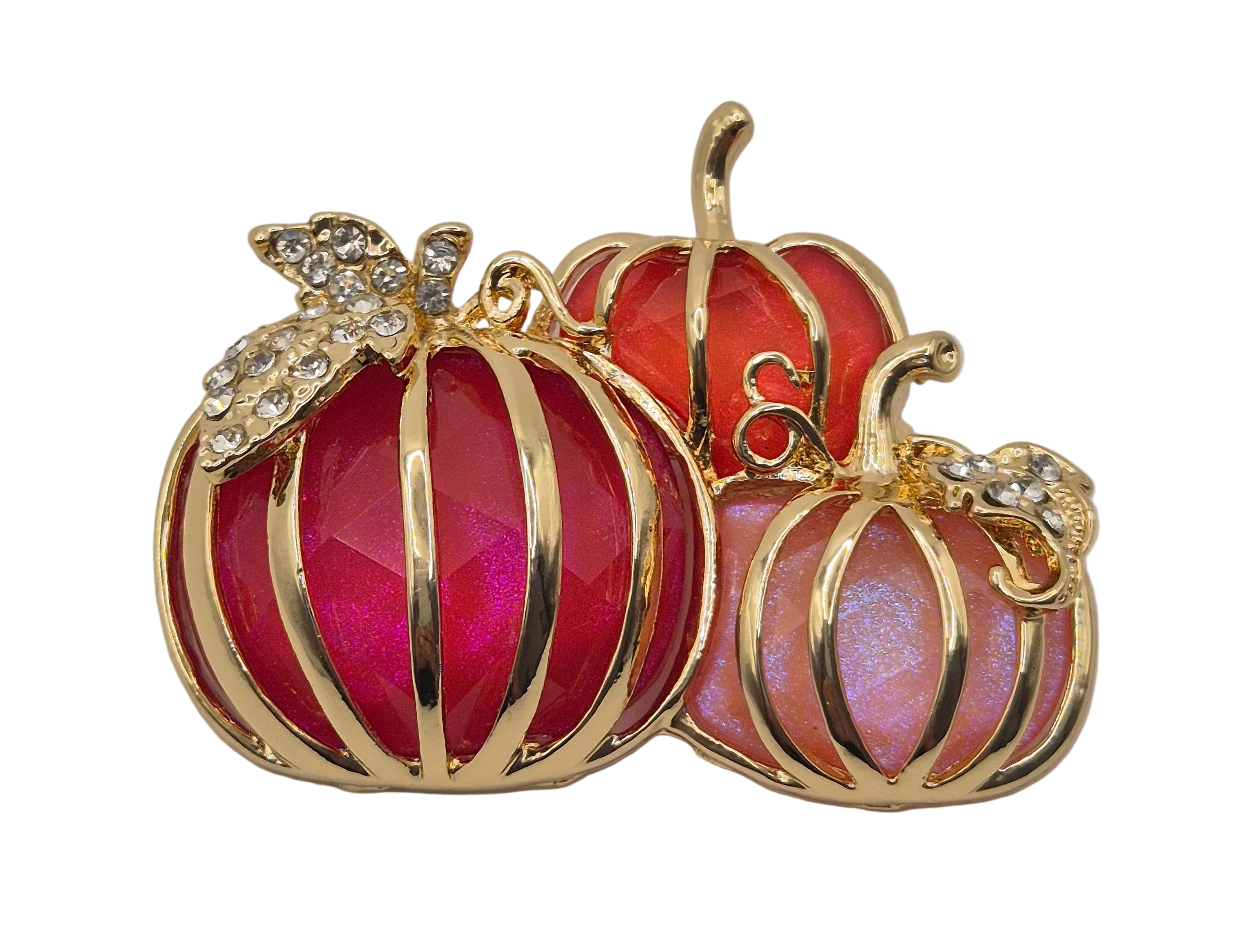 A gold-toned pumpkin-shaped brooch featuring faceted red and iridescent pink enamel, accented with rhinestone details on the stems and leaves, shown against a plain white background.