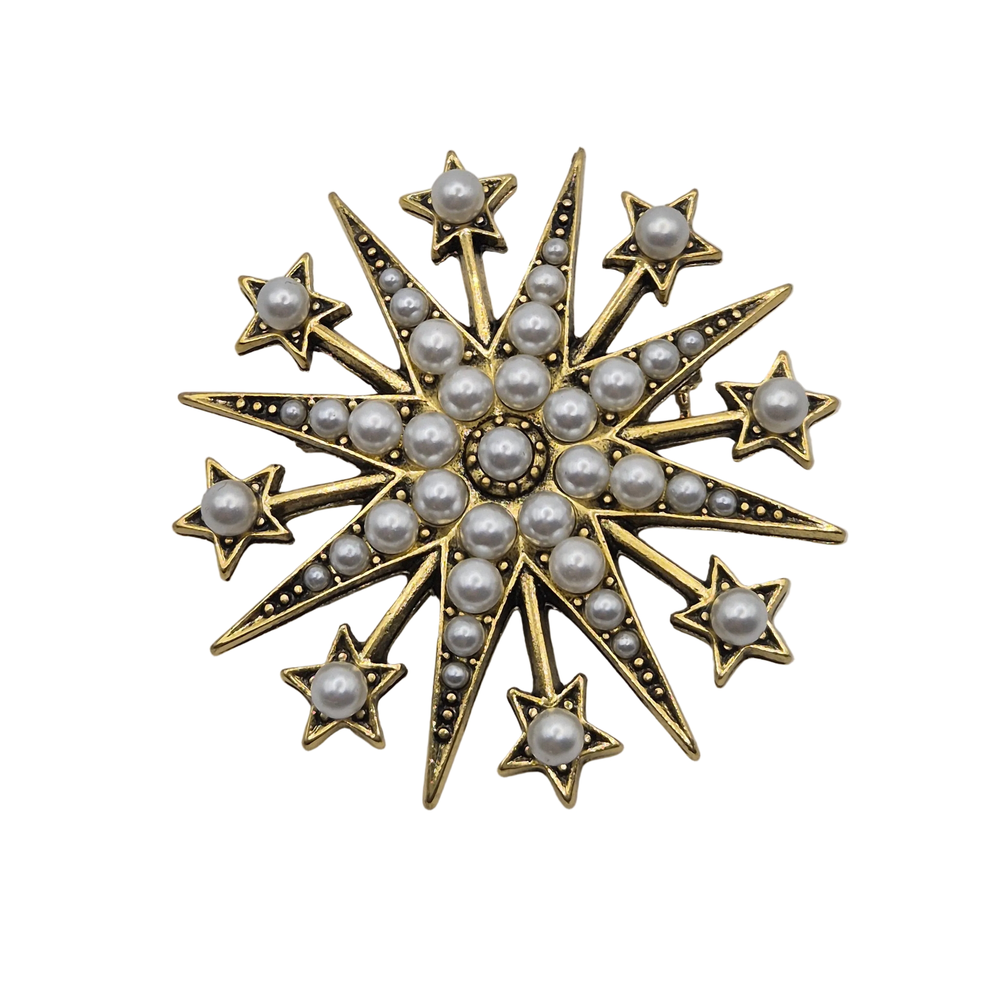 A gold-toned starburst brooch featuring multiple rows of white faux pearls and small dark bead accents, isolated on a white background.