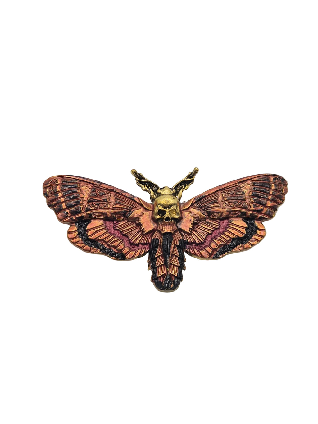 Decorative moth-shaped brooch on a plain background