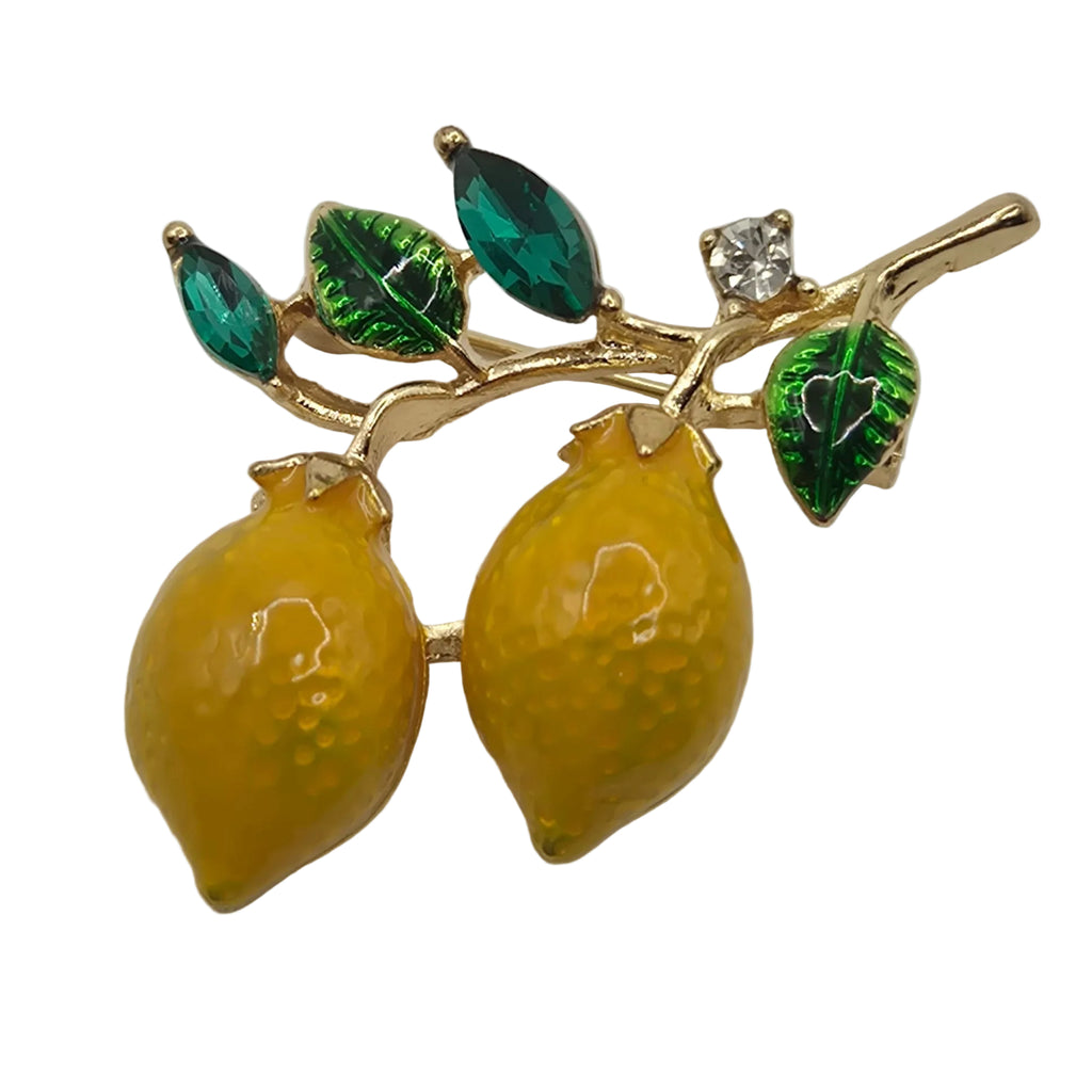lemon and leaf design brooch on a light gray background