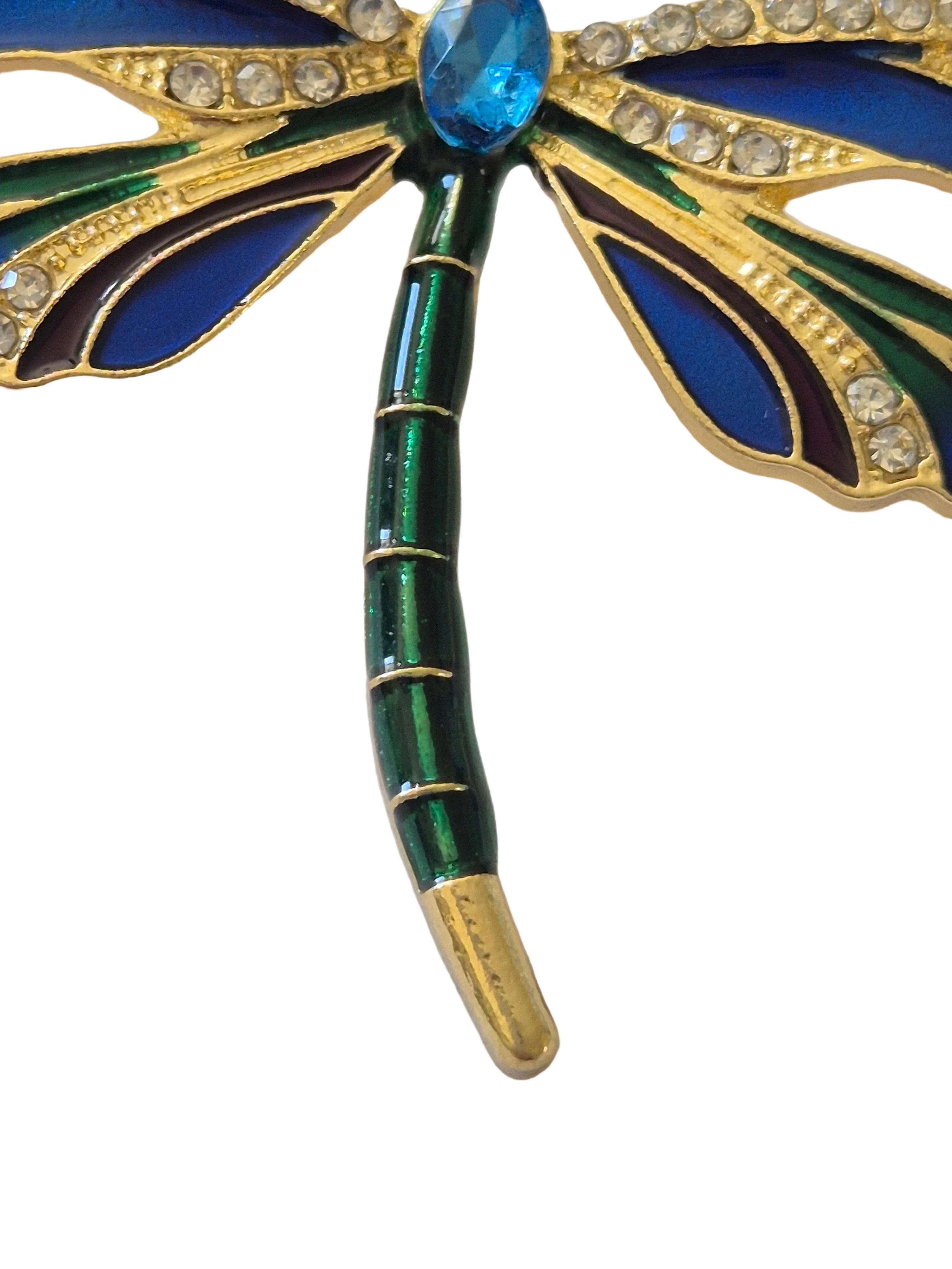 dragonfly brooch with blue and green details on a white background