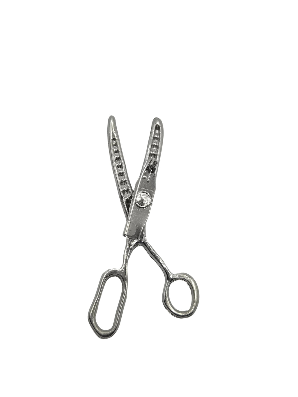 Pair of silver scissors brooch on a gray background