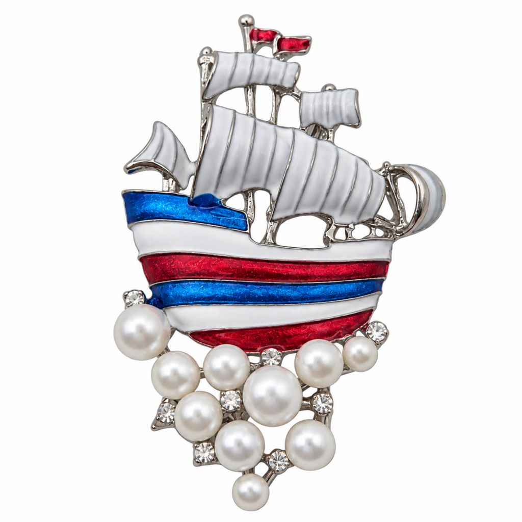 A silver-toned ship-shaped brooch featuring white enamel sails, red and blue striped hull details, faux pearls hanging from the bottom, and small clear rhinestones, shown on a plain white background.