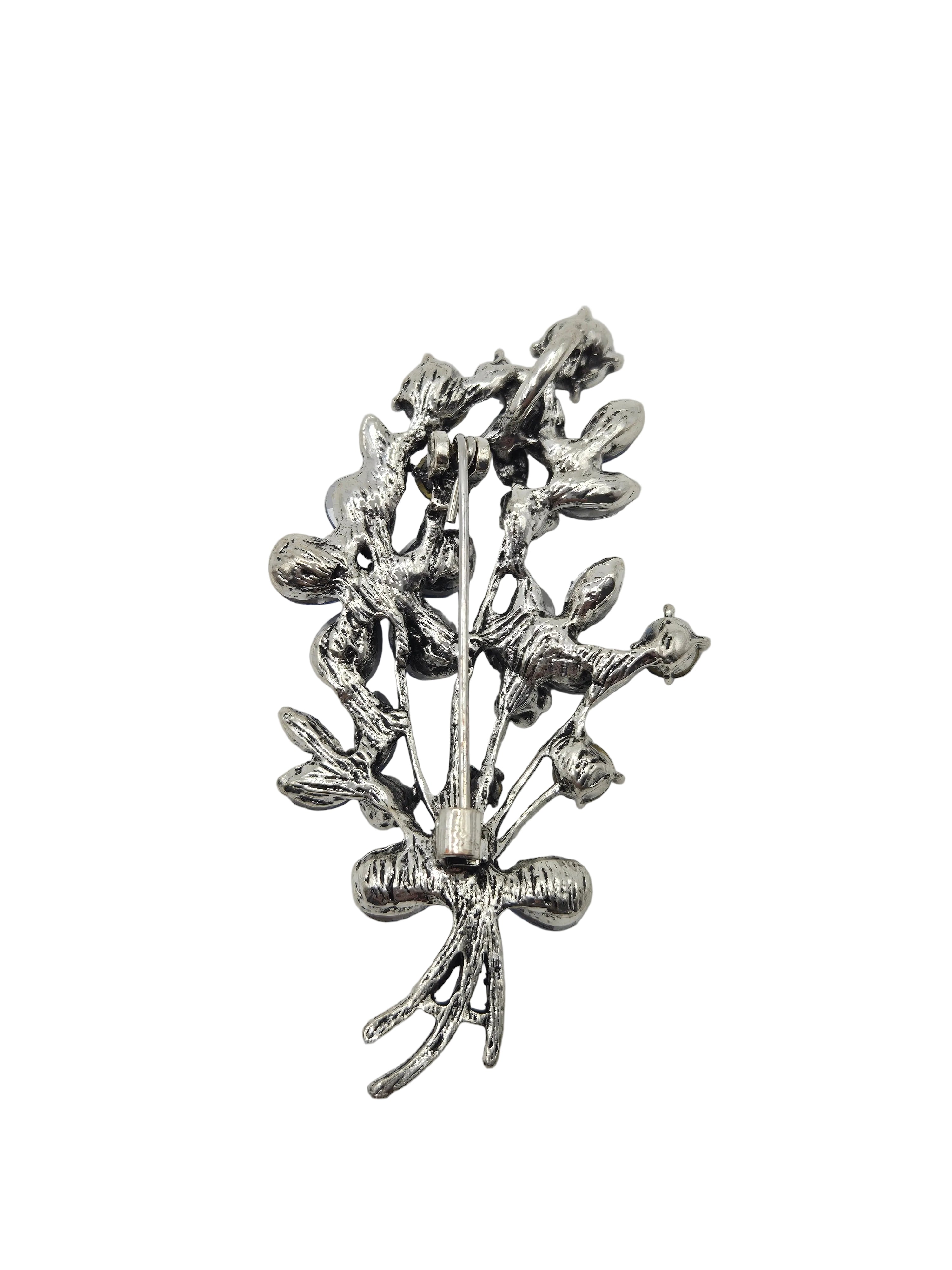 Silver blue brooch with intricate design on a gray background