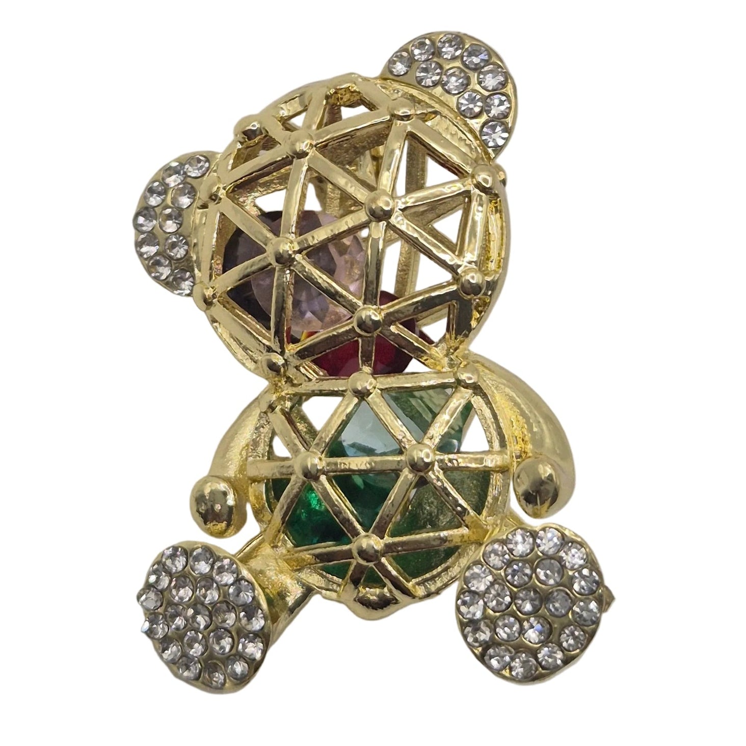 A gold-toned teddy bear ring embellished with clear pavé crystals on its ears, feet, and chest, featuring a central faceted gemstone with green and pink inlay, set against a plain white background.