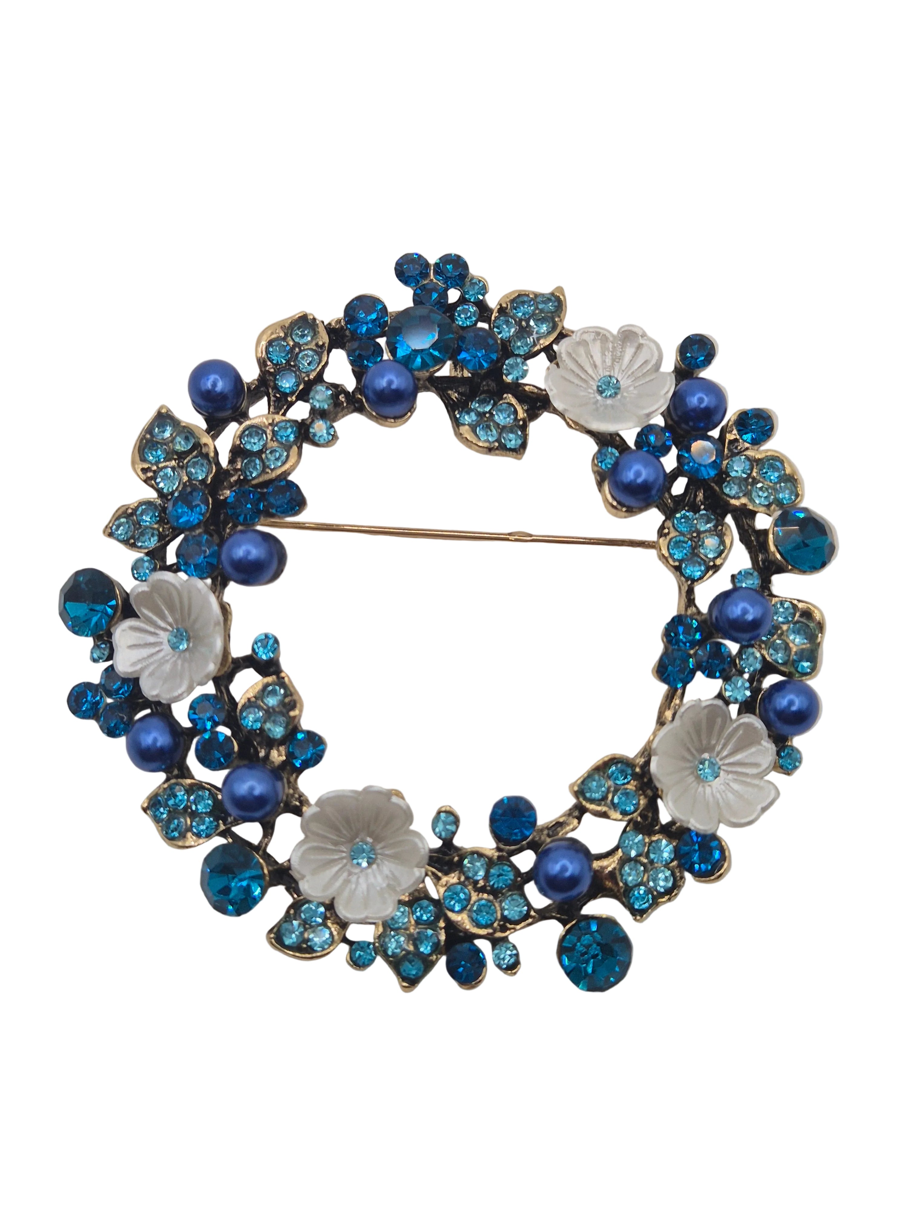 Decorative brooch with blue and white floral design on a white background