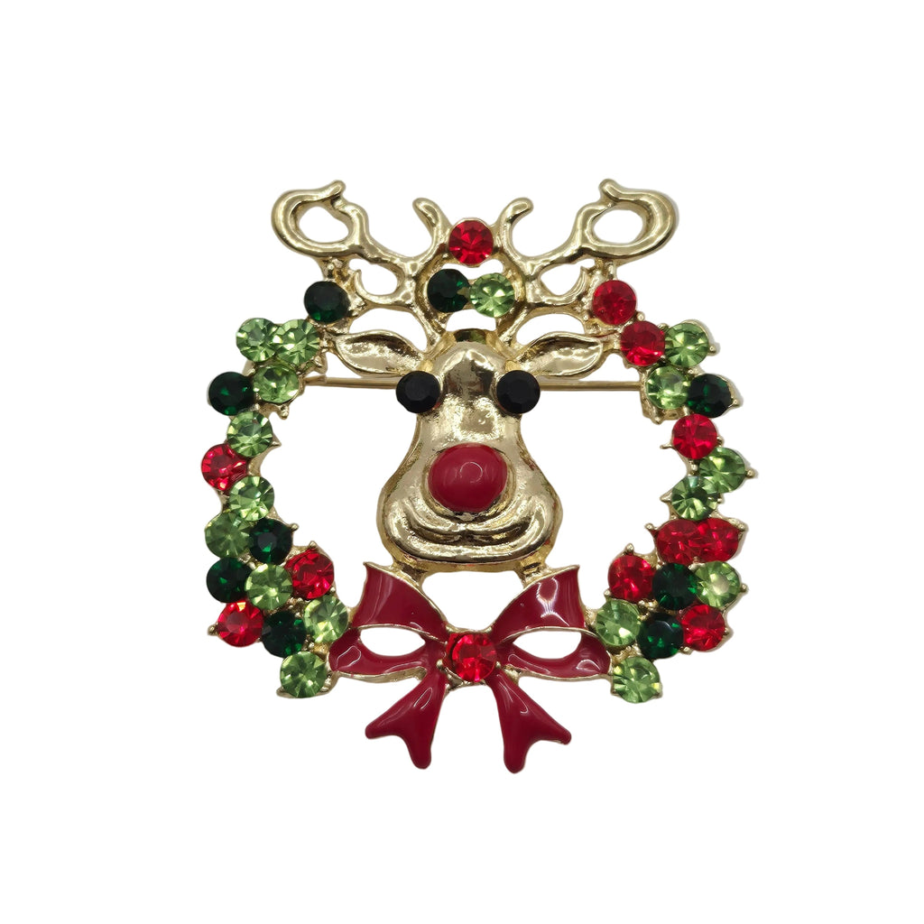 A gold-toned Christmas reindeer brooch featuring green and red rhinestone accents in a wreath design, with a red bow at the bottom, photographed on a plain white background.