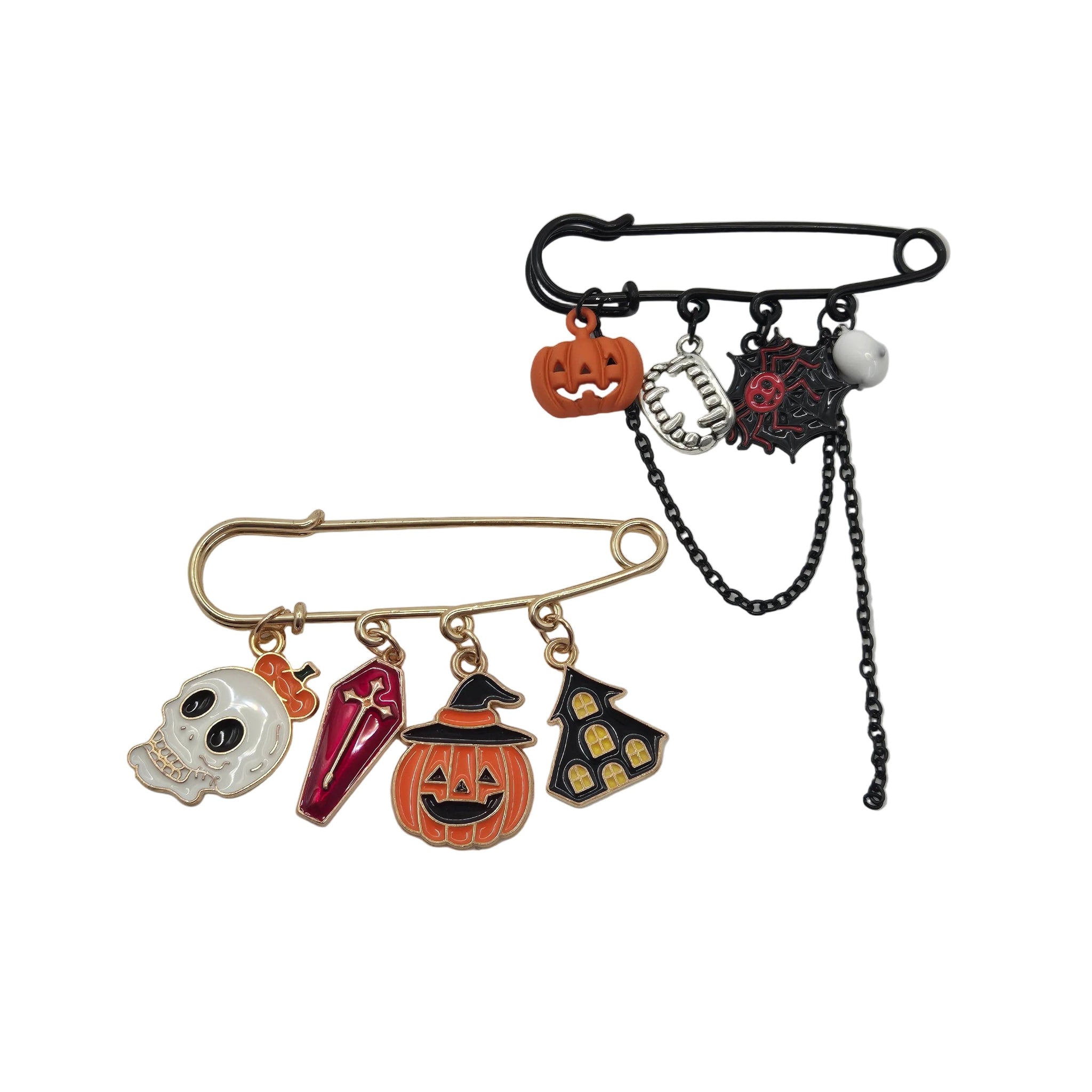Two Halloween-themed safety pins brooches displayed on a white background. The top safety pin is black with orange, silver, and red charms including a jack-o'-lantern, spider, and skull.