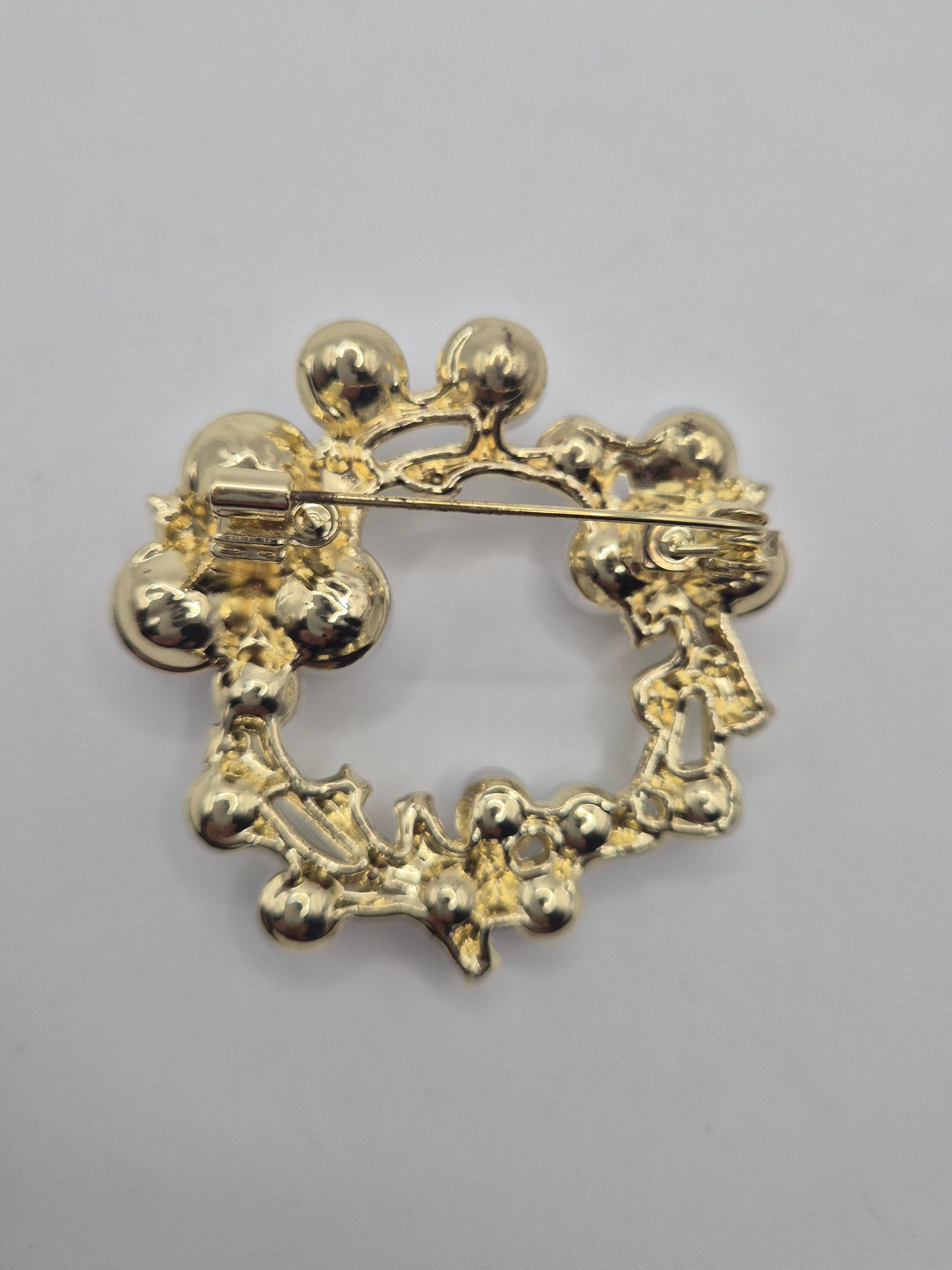 Gold pearl brooch with floral design on a gray background