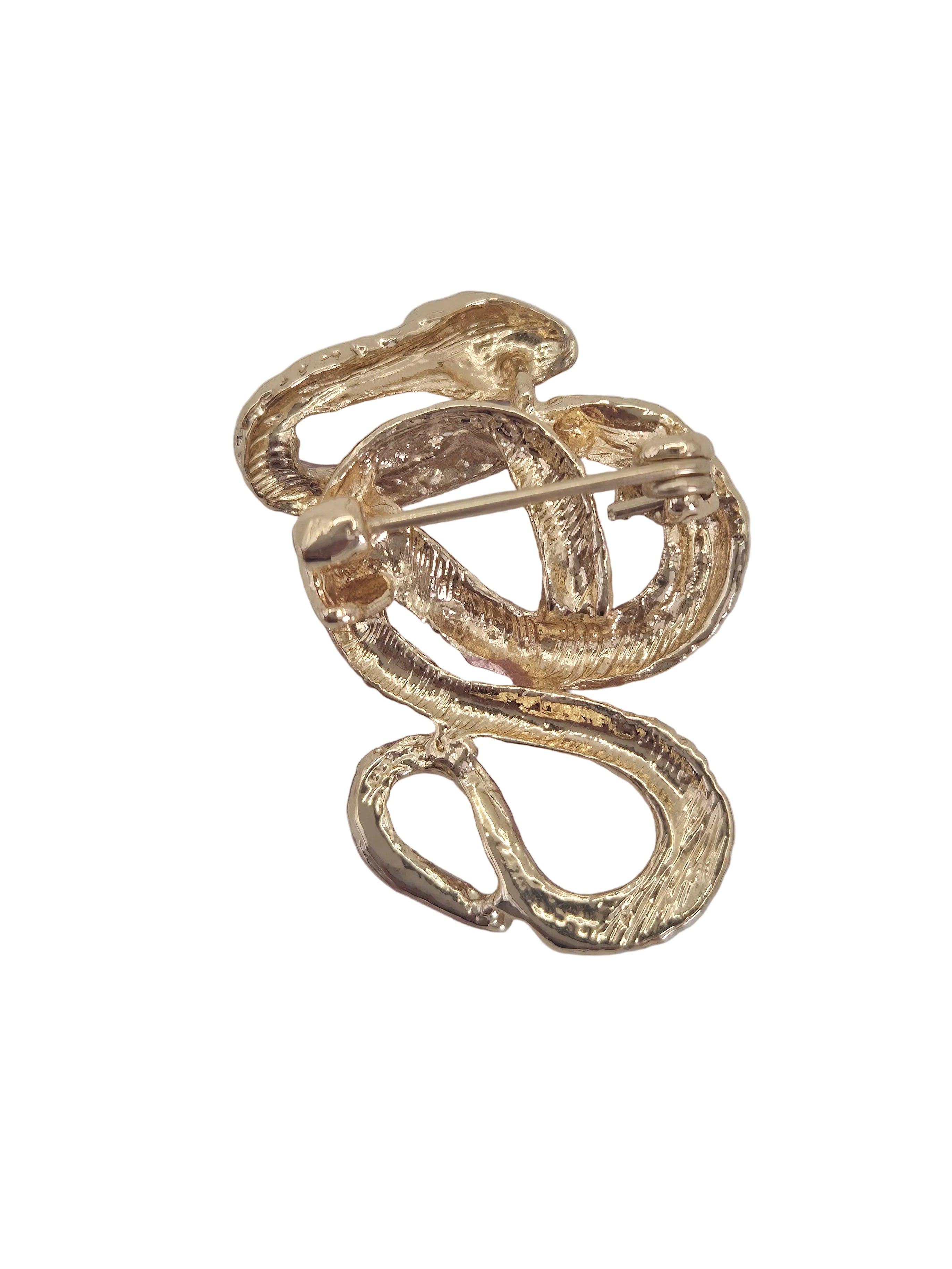 A gold snake-shaped brooch with a textured finish and a pin back, shown on a plain white background.
