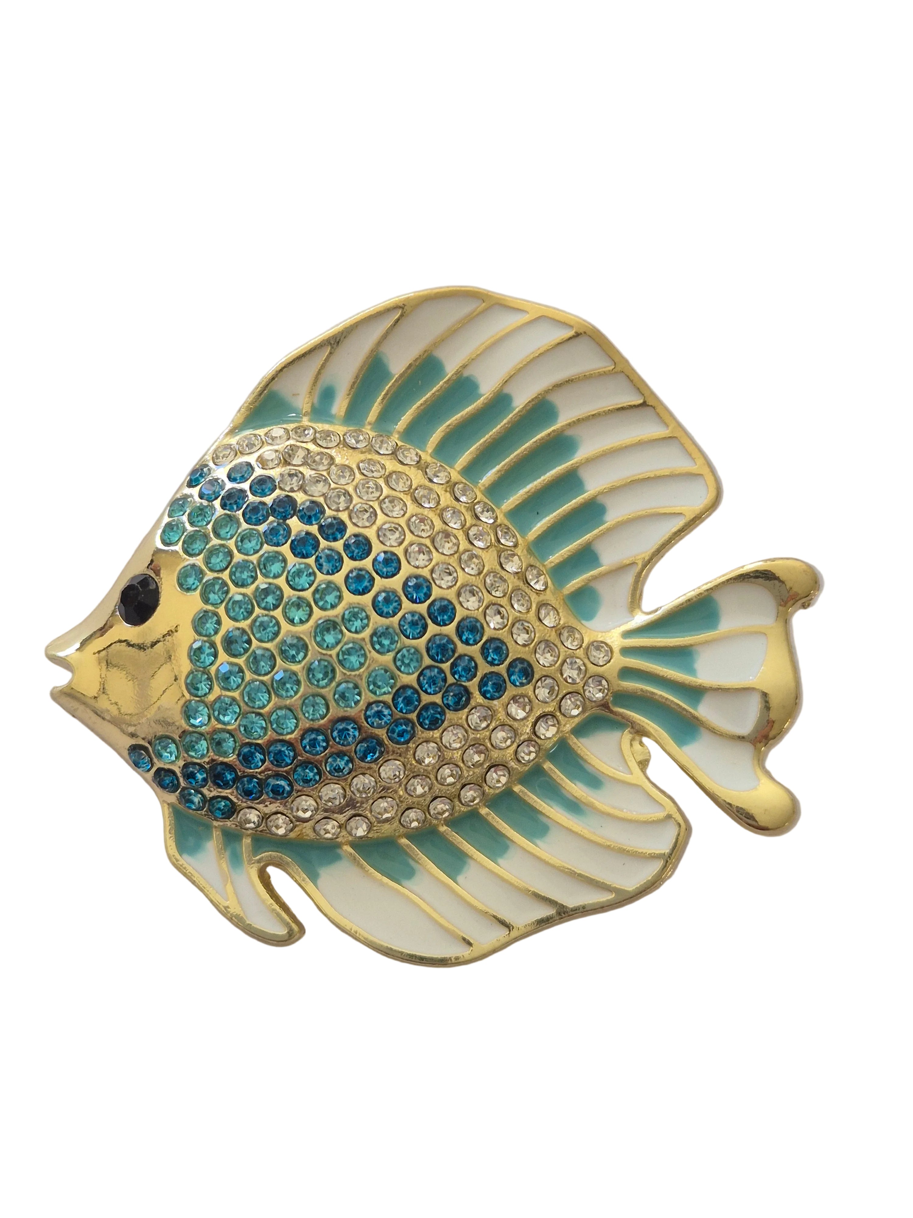 Decorative fish-shaped brooch with gold and blue design on a light gray background