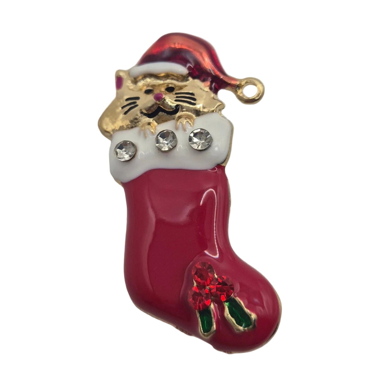 A Christmas stocking brooch featuring a gold cat wearing a red Santa hat, with rhinestones on the white cuff and a green wreath detail at the bottom, set against a plain white background.