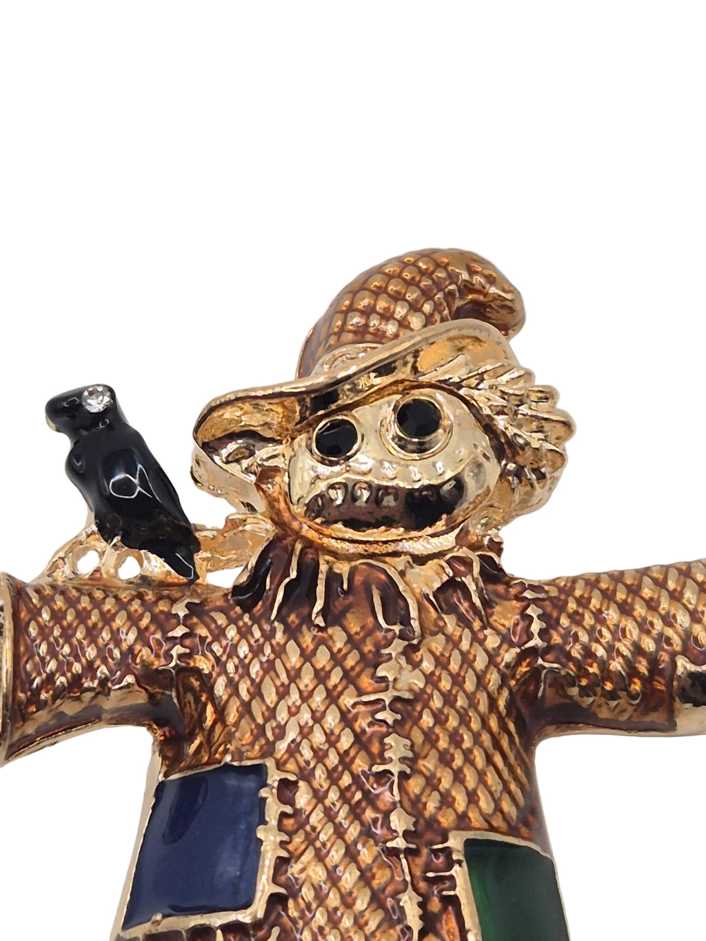 scarecrow brooch blue and black accents on a light gray background