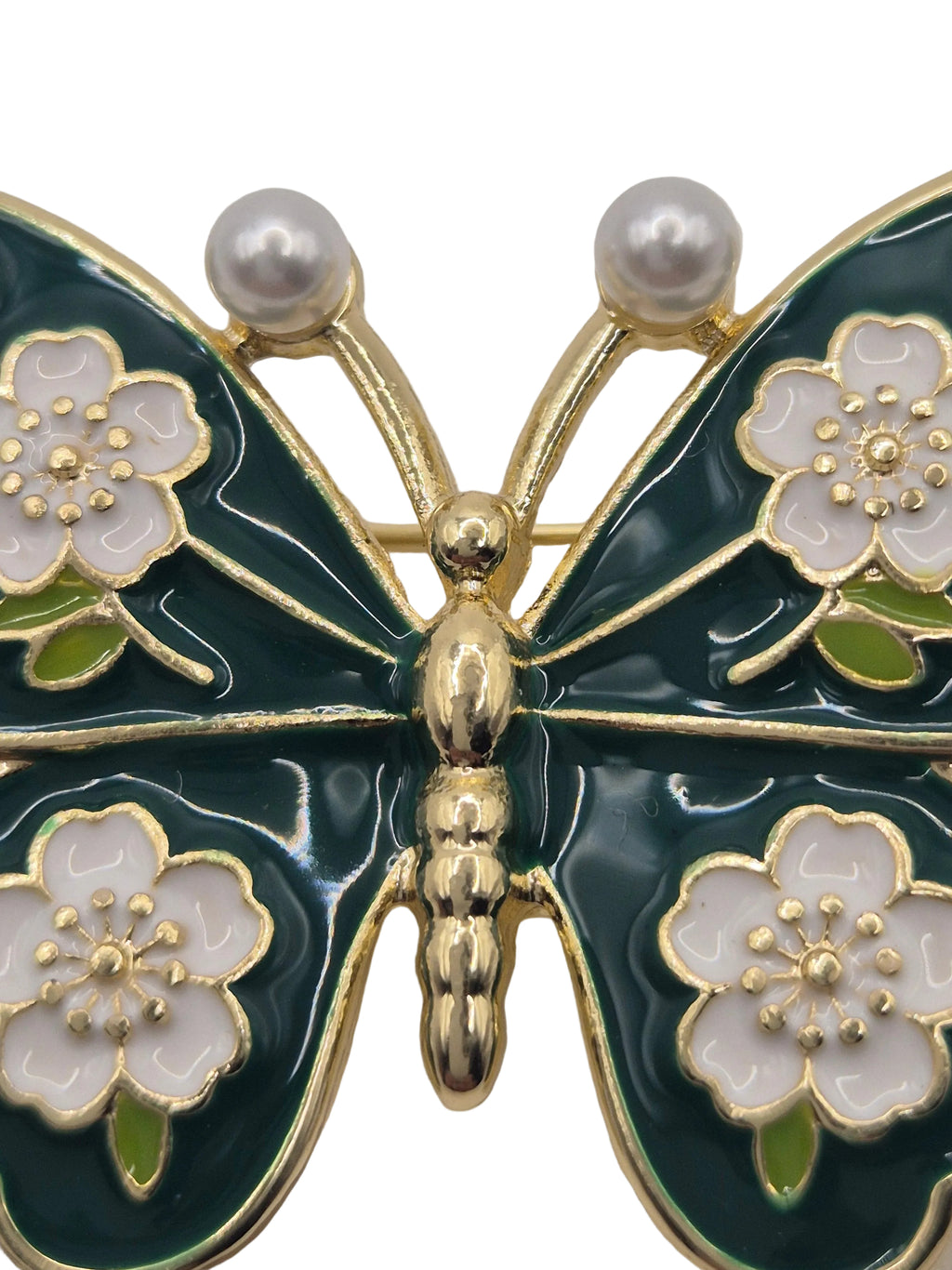 Butterfly brooch with floral and pearls detail on a white background