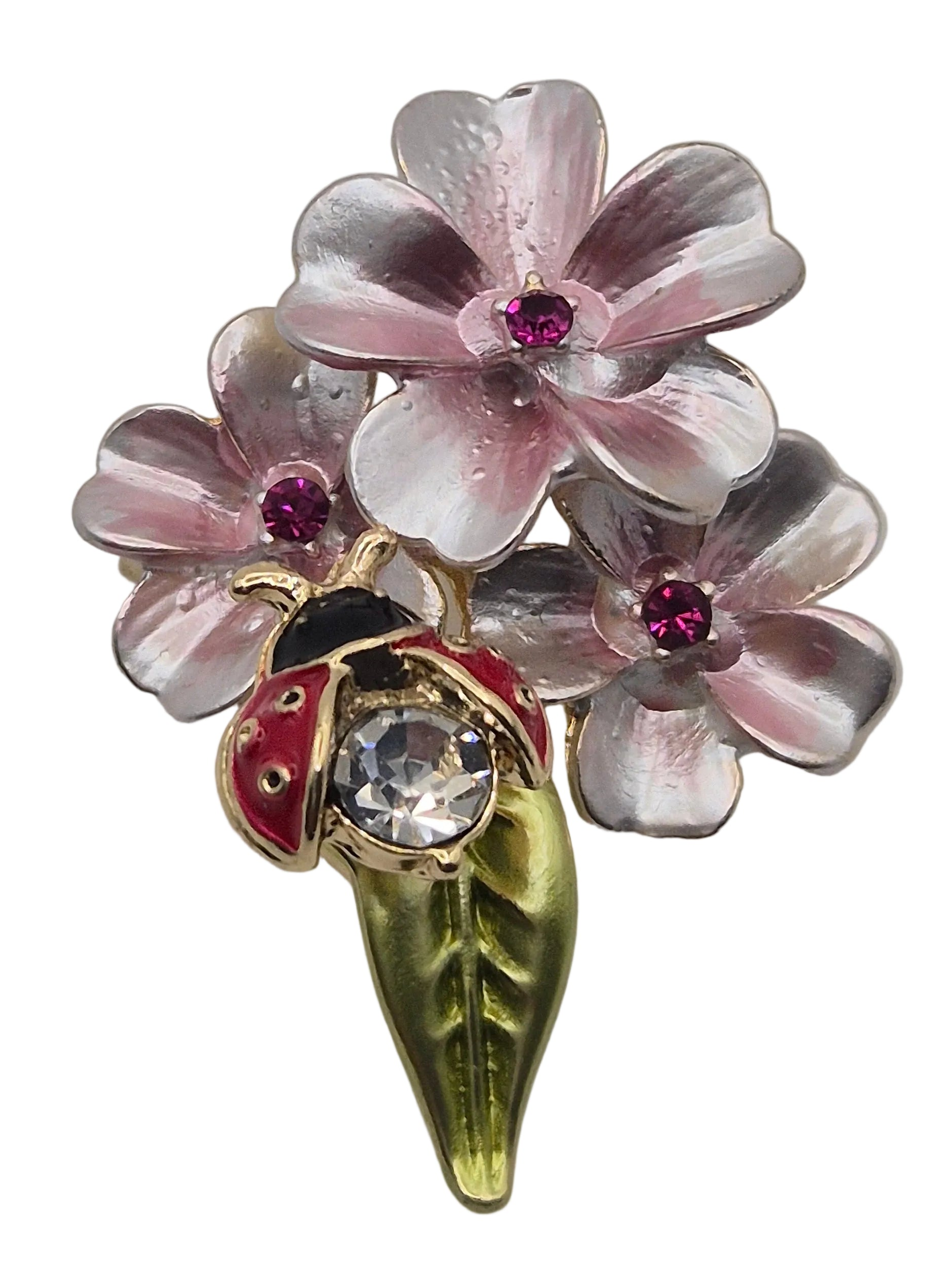A vintage-style floral brooch featuring three pink and silver cherry blossoms with small red gem accents, a gold leaf stem, and a ladybug detail on a white background.