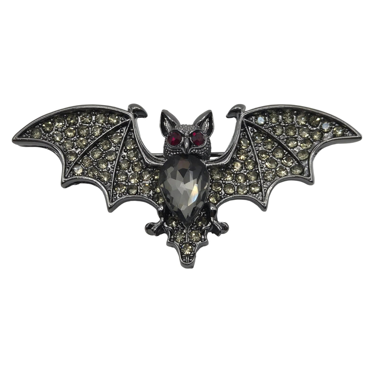 A gothic-style bat brooch featuring a silver-toned metal body, wings paved with small clear rhinestones, and red gemstone eyes, shown on a plain white background.