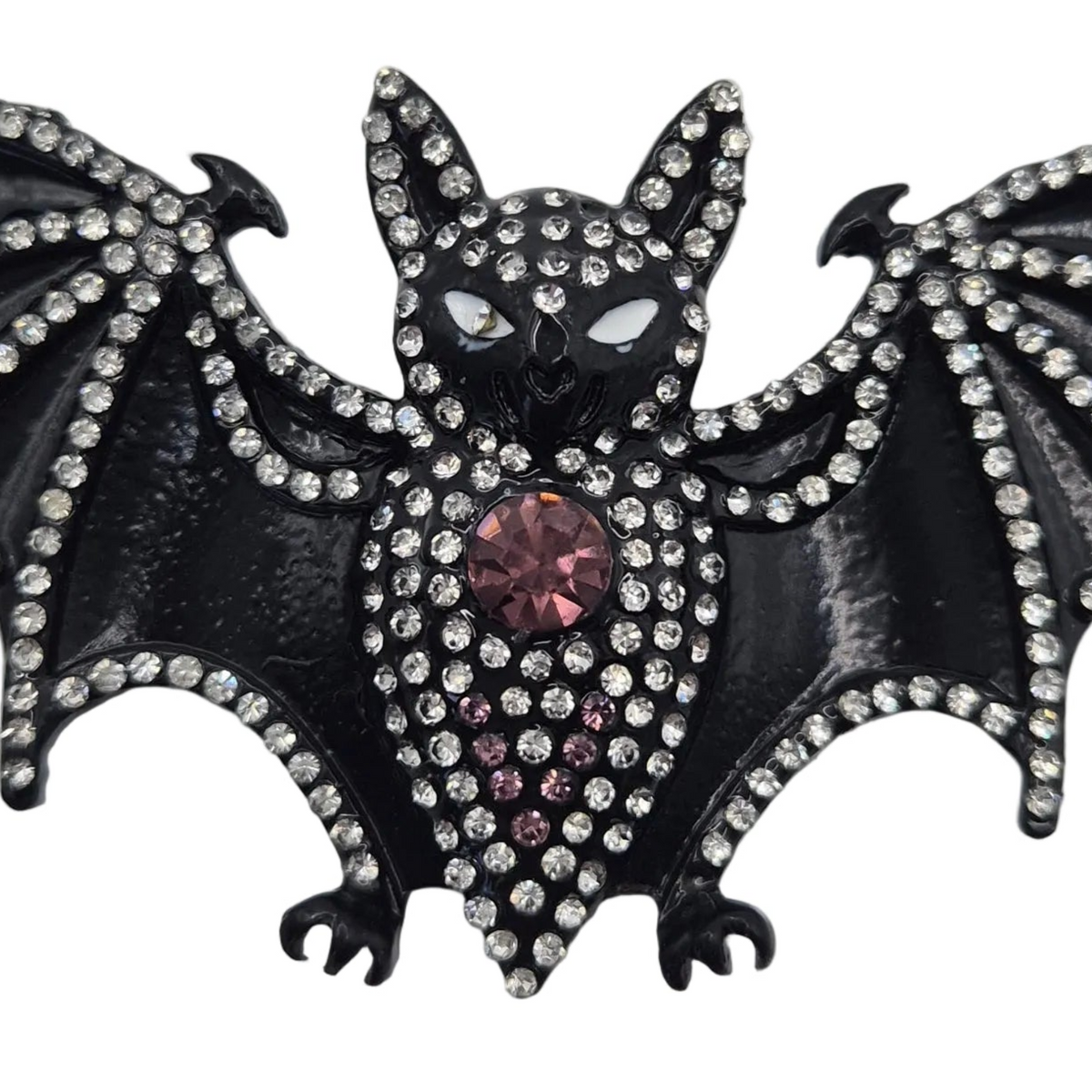 Black bat-shaped brooch embellished with clear rhinestones and a central pink faceted crystal, shown on a plain white background.