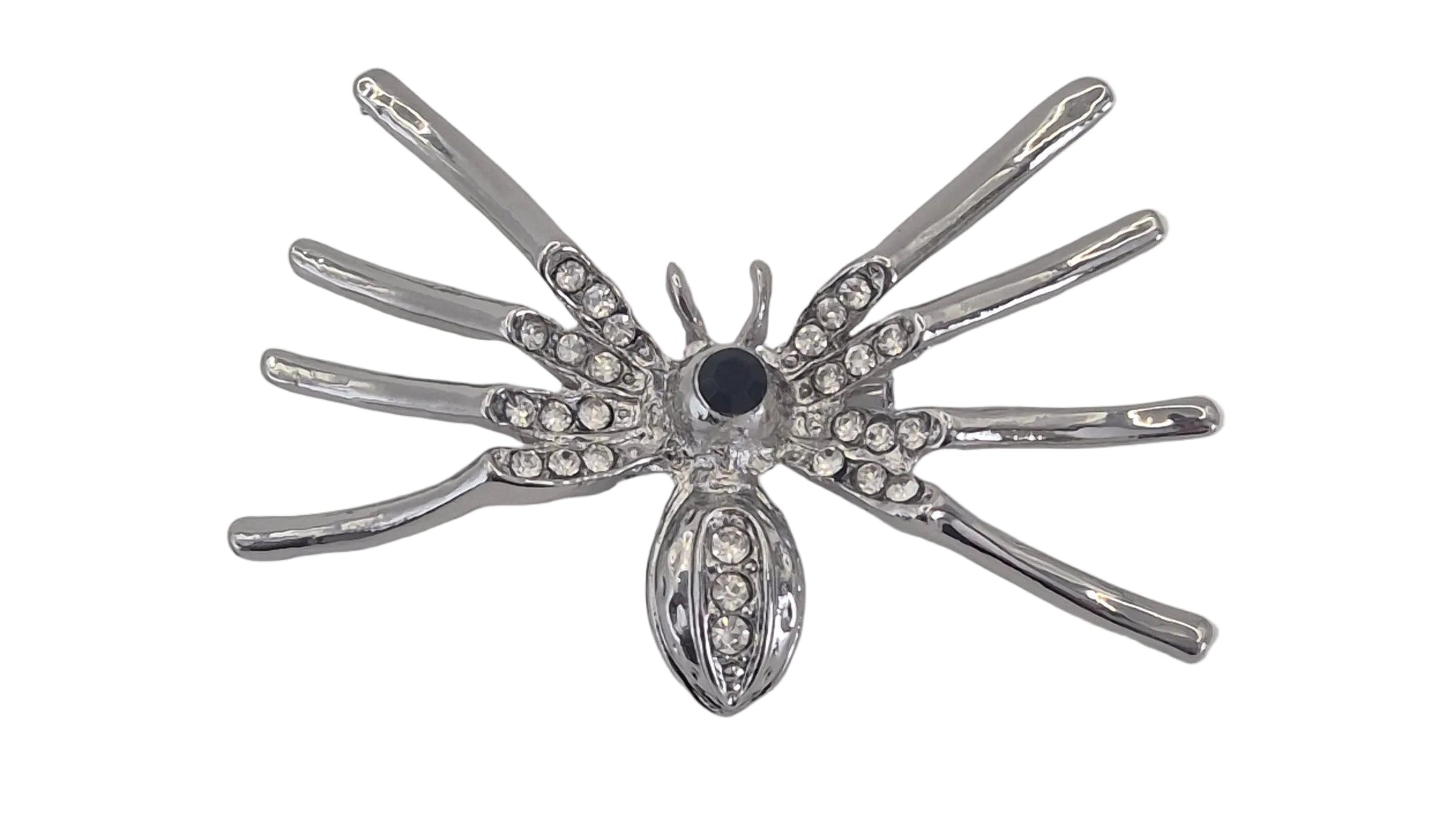 A silver spider brooch embellished with clear rhinestones and a central dark blue gemstone, shown on a plain white background.