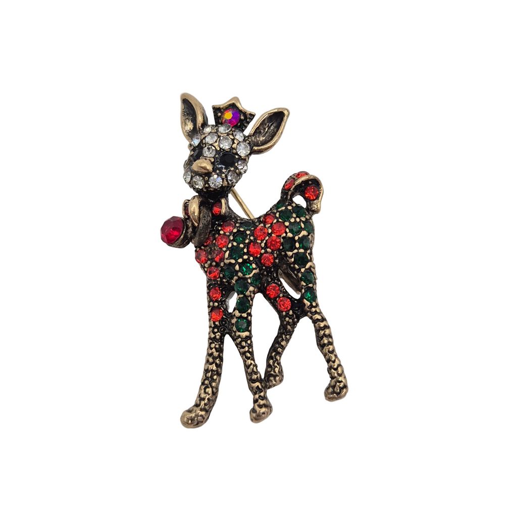 A decorative reindeer-shaped brooch with an antiqued gold-tone metal finish, embellished with red and green rhinestones and a clear crystal face, photographed on a plain light background.