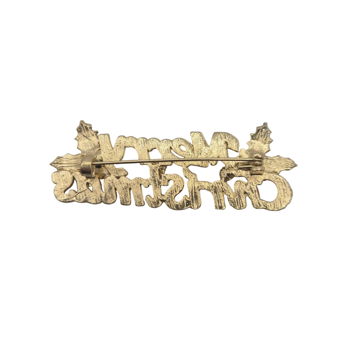 Reverse gold tone side of 'Merry Christmas' brooch pin showing pin mechanism, displayed on a plain white background. 