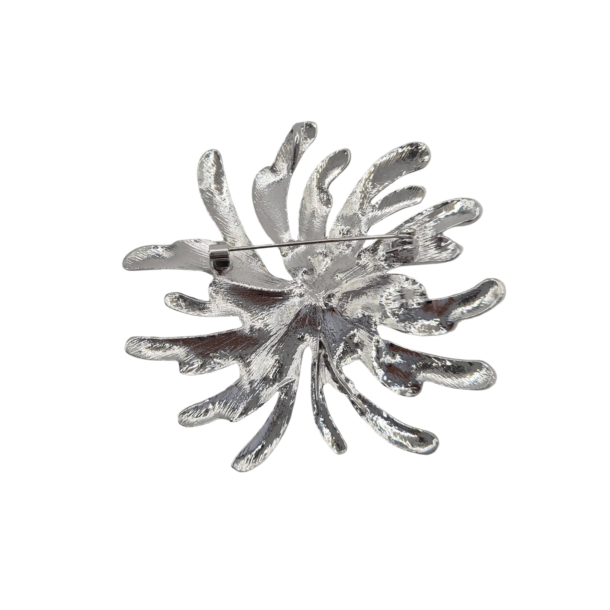A silver toned metal firework burst brooch displayed against a plain white background.