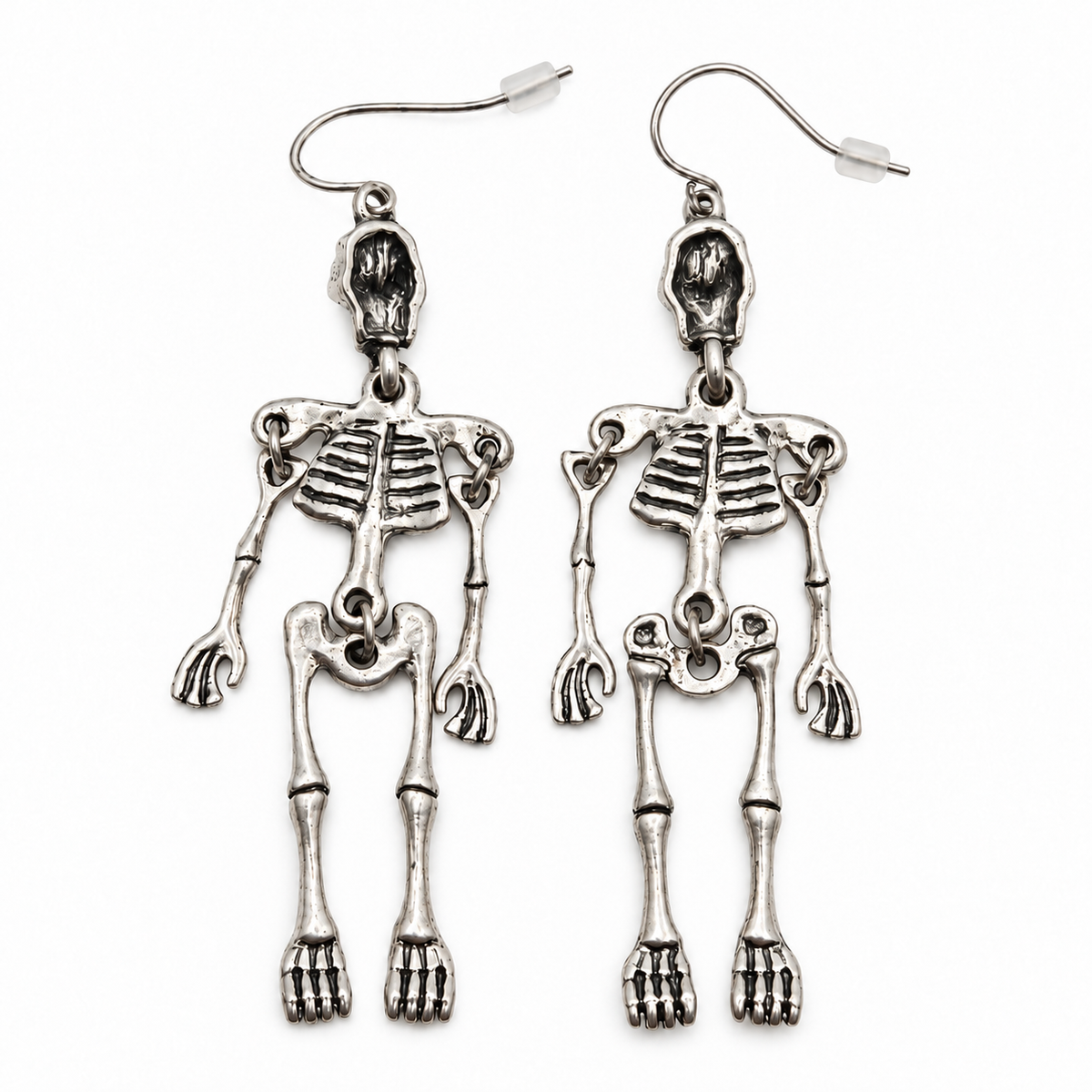 Reverse of silver-tone skeleton drop earrings, showing the backs of the skulls, jointed limbs and curved hooks on a white background.