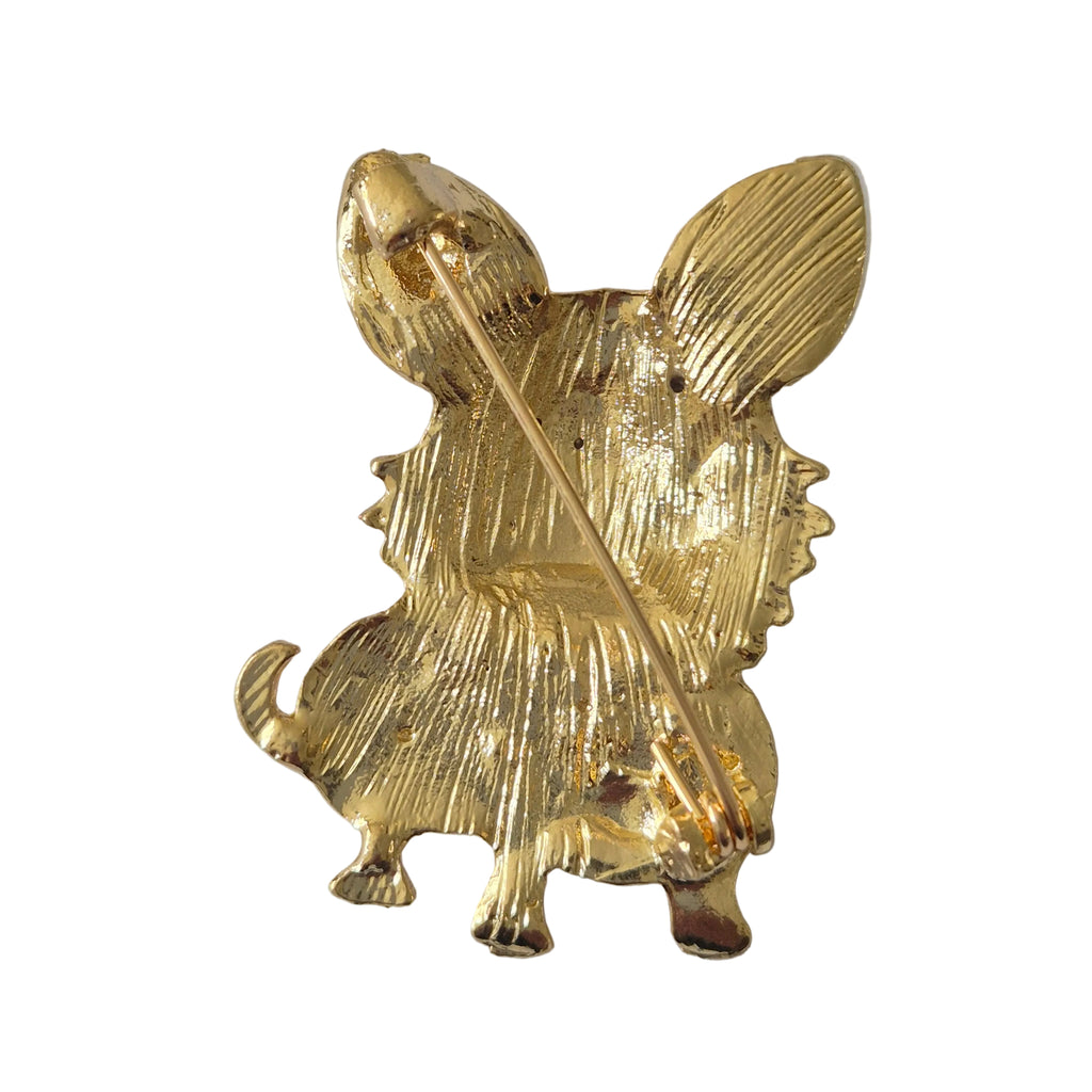 Gold dog brooch with rhinestone design on a light gray background