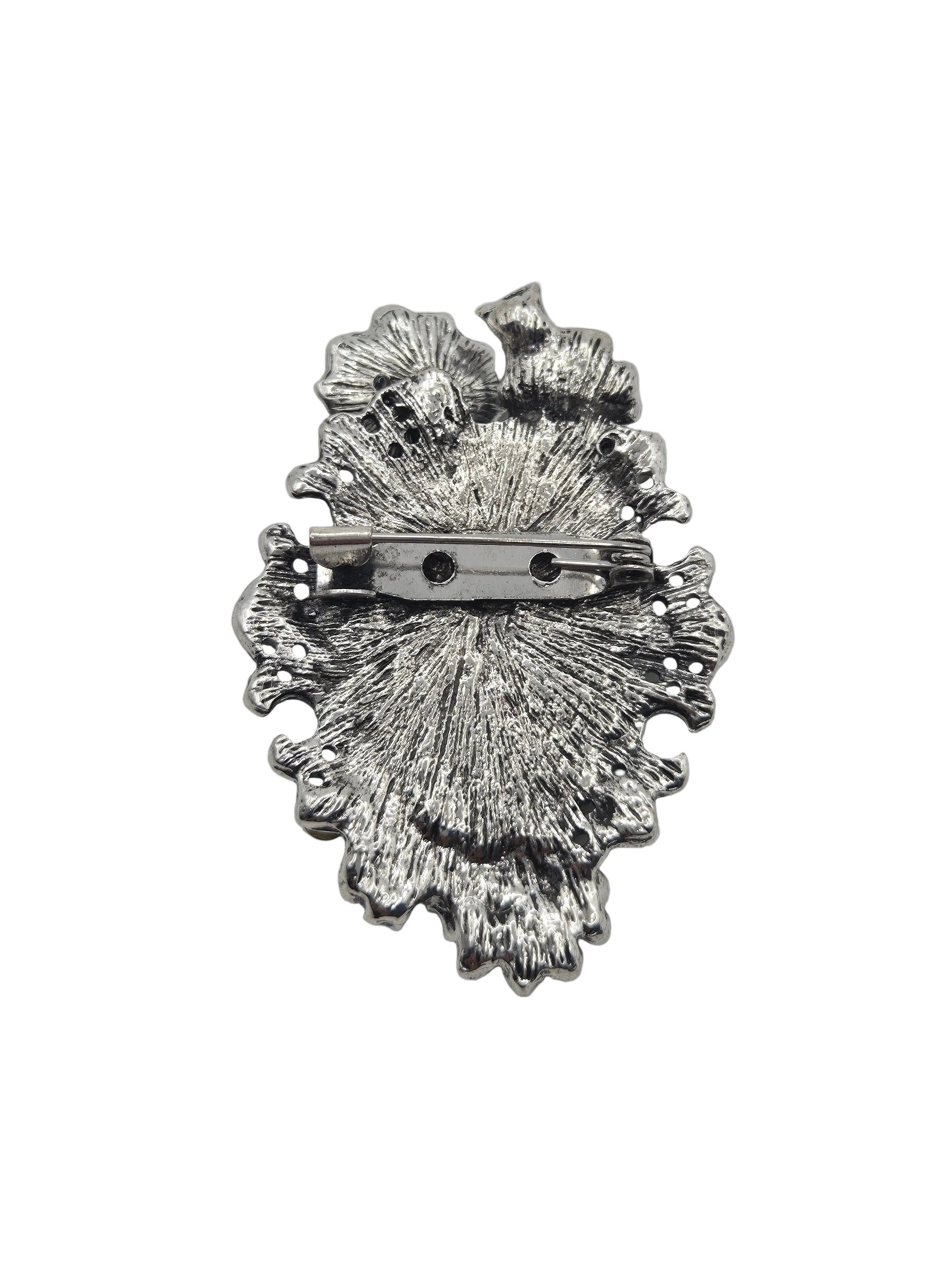 Silver-toned textured metal brooch with a pin clasp, shown from the back on a plain white background.