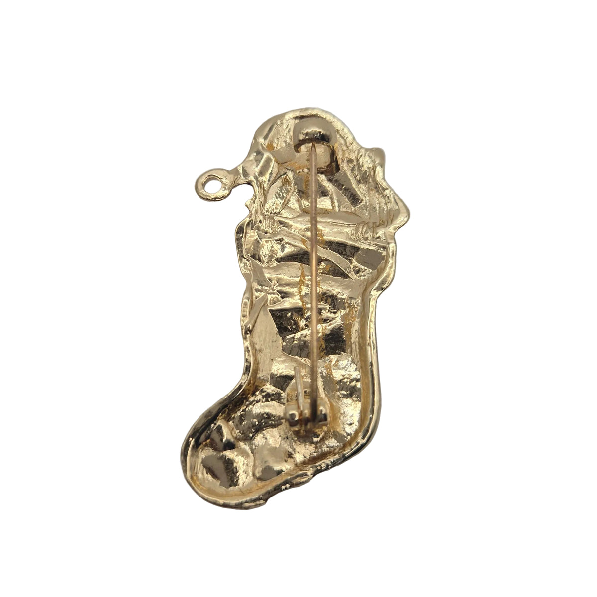 A small gold Christmas stocking-shaped brooch or charm with a visible pin mechanism, photographed on a plain white background.