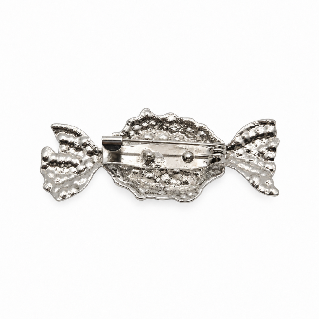Reverse silver toned side of a candy brooch pin, displayed against a plain white background.