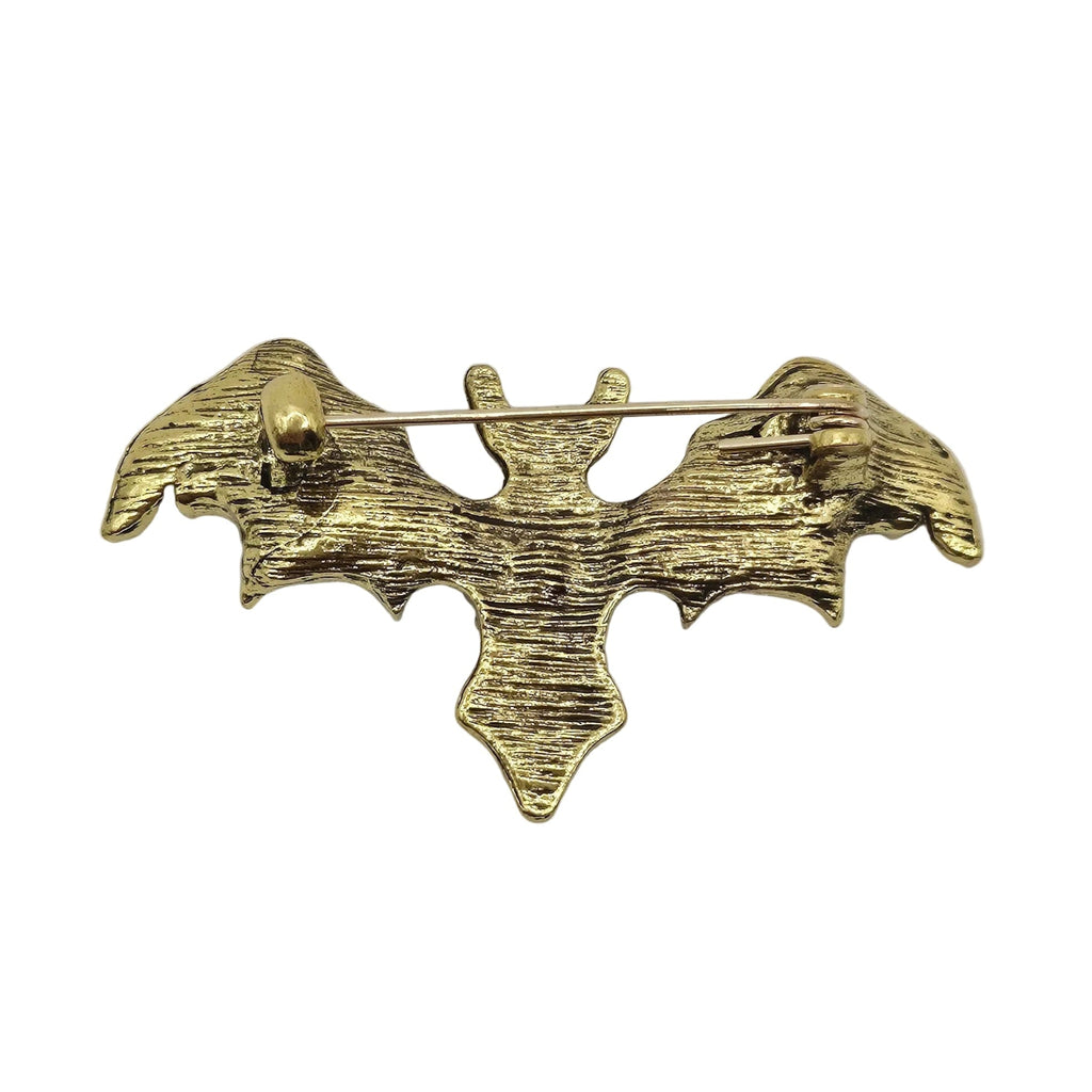 A small gold-toned metal pin shaped like a stylized bat or winged figure, photographed on a plain white background.