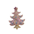 A Christmas tree-shaped brooch featuring pink and gold-tone metalwork, embellished with iridescent rhinestones and a small purple star topper, set against a plain white background.