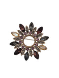 jewelled wreath brooch with multicolored gemstones on a white background