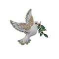 A white enamel dove brooch with gold-plated trim, blue enamel wing details, rhinestone embellishments on the wings, and a green leafy branch in its beak, shown on a plain white background.
