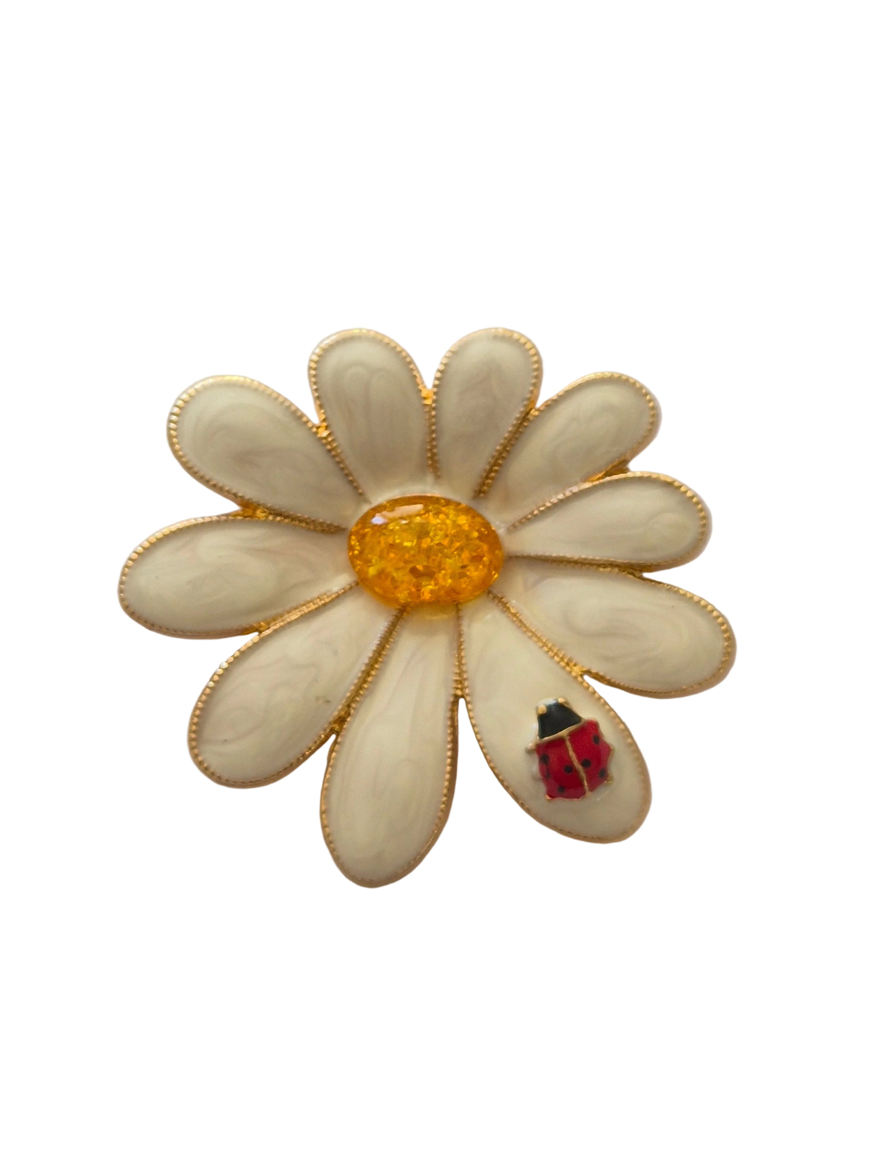 White flower-shaped brooch with a red ladybird on a white background