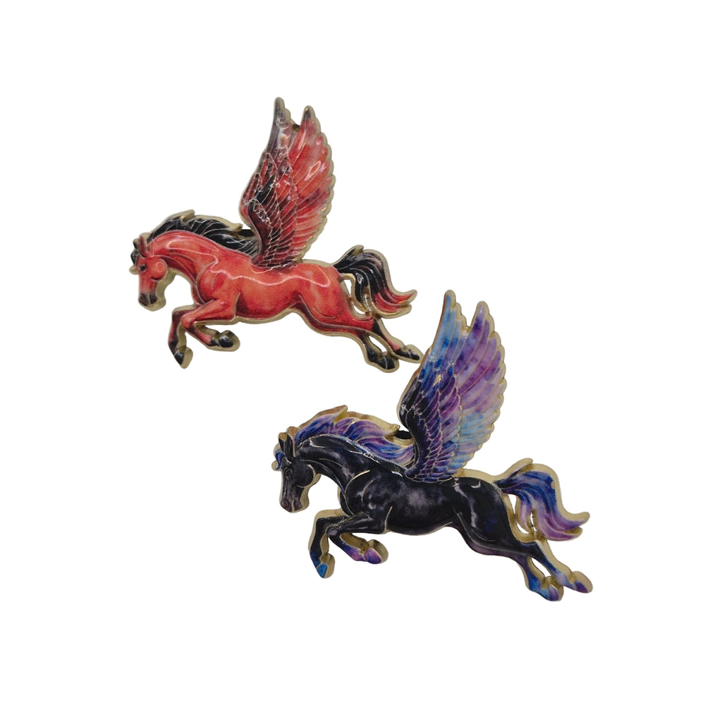 Two enamel winged horse pins on a plain white background, one red with dark wings and one black with purple and blue wings.