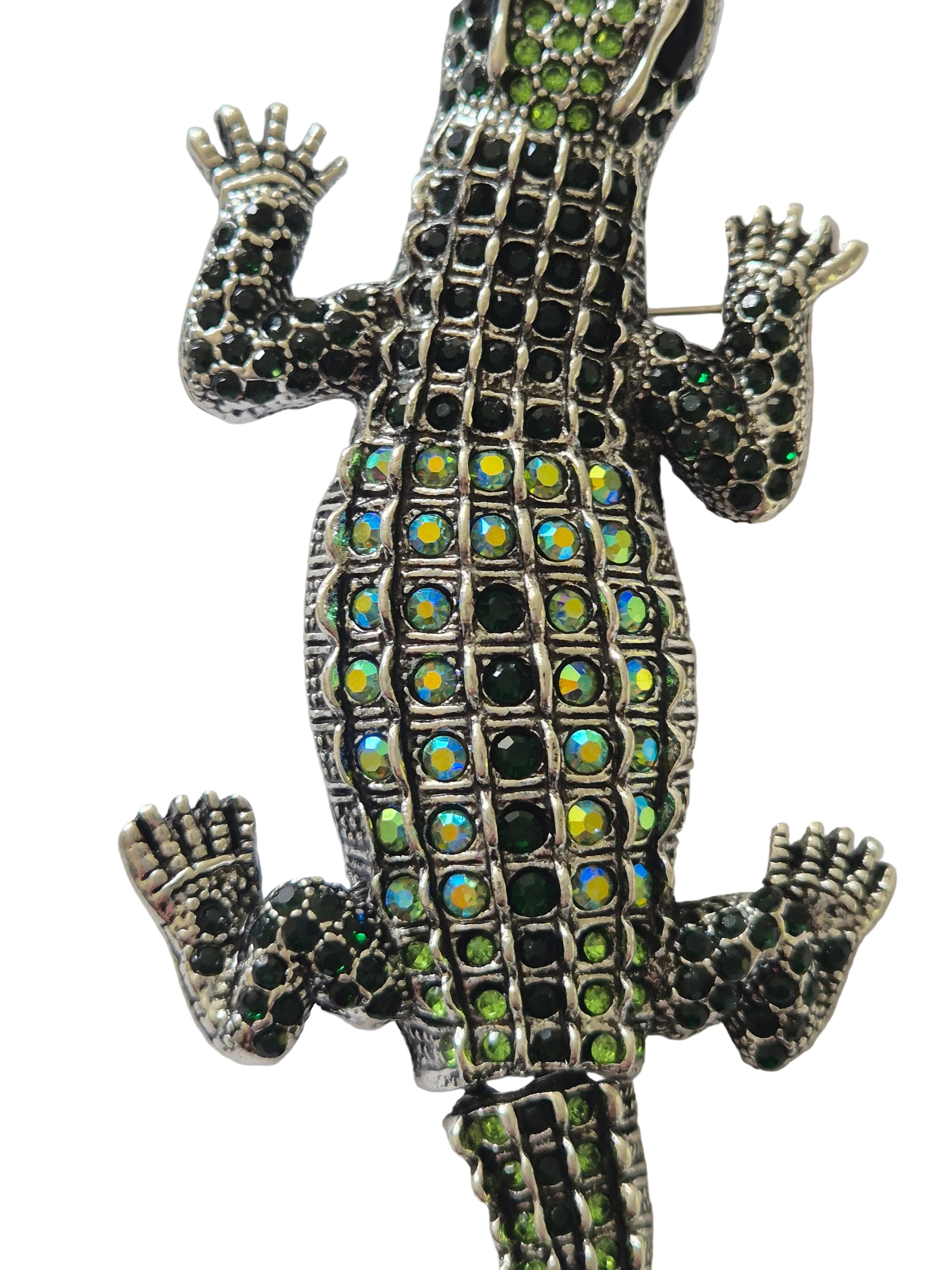 Decorative crocodile brooch with gemstones on a white background