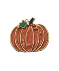 A pumpkin-shaped brooch with a glossy orange enamel body, gold-tone metal outlines, a small green leaf accent, and a black stem, shown on a plain white background.
