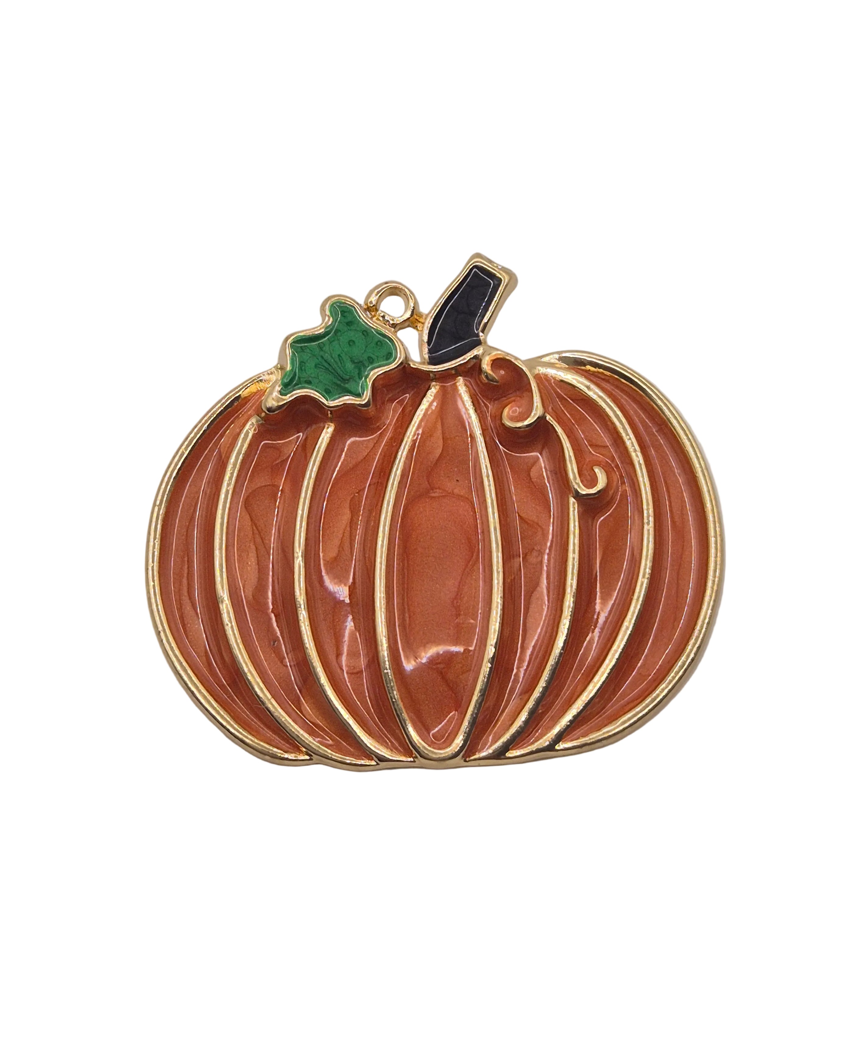 A pumpkin-shaped brooch with a glossy orange enamel body, gold-tone metal outlines, a small green leaf accent, and a black stem, shown on a plain white background.