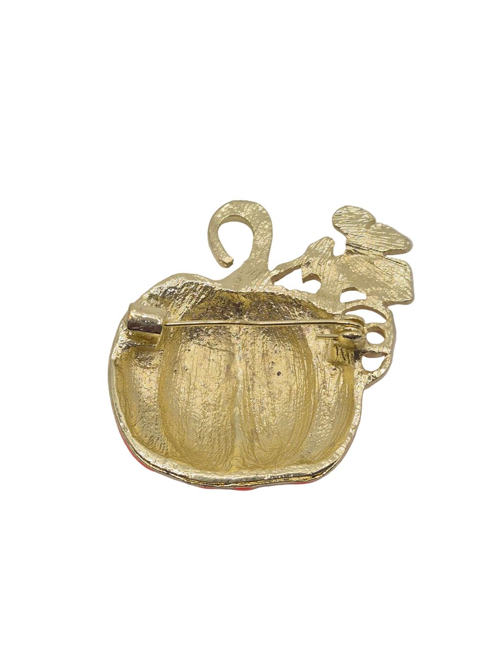A gold-toned pumpkin-shaped brooch with a textured finish and a leaf detail on the side, shown against a plain white background.